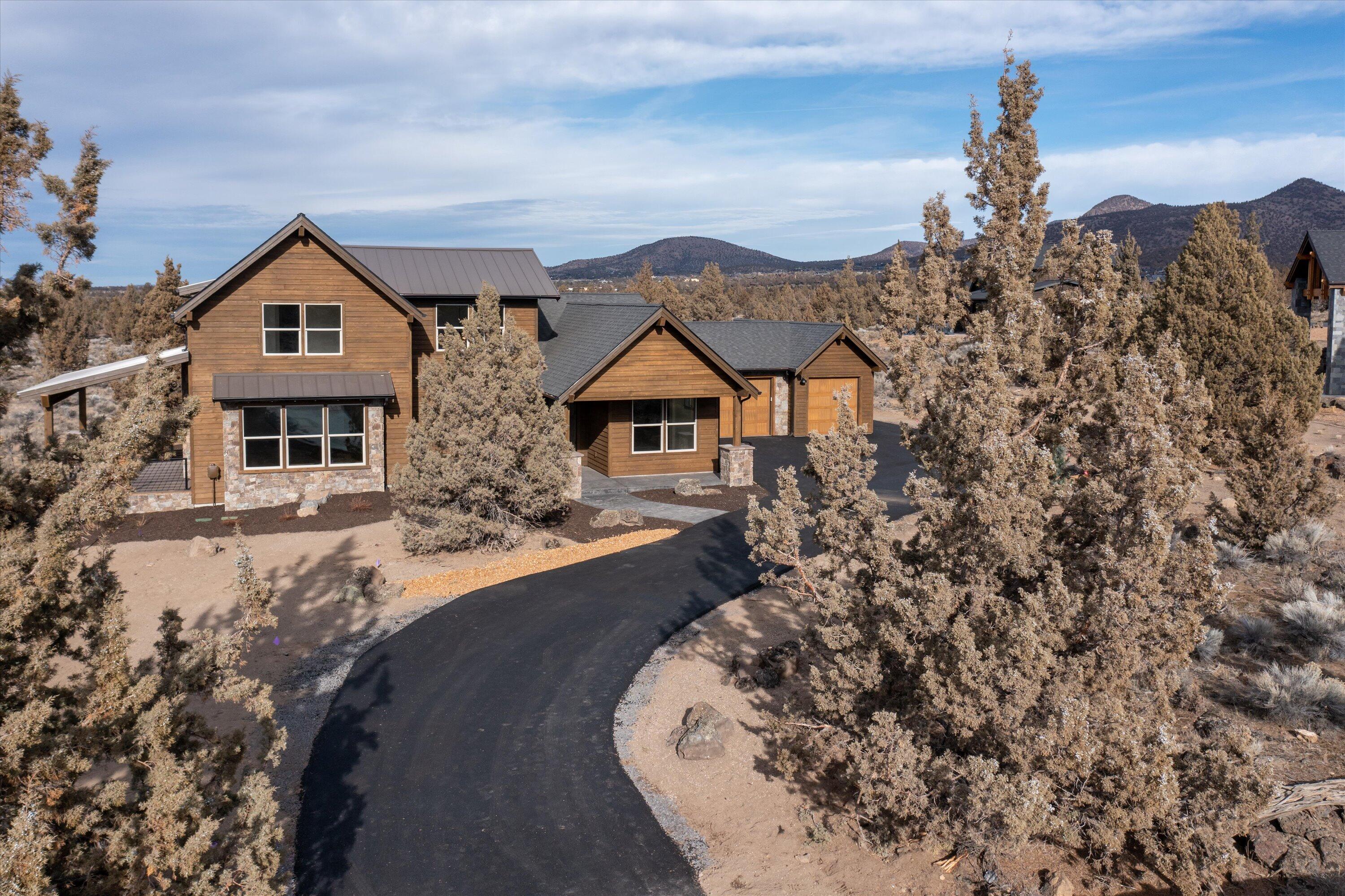 Stunning, New Construction, two story ranch-style home accentuated with stone accents and stained wood siding on the exterior. Take in the Cascade Mountain views on the back deck while sitting by the indoor/outdoor fireplace. Inside, you will find an open great room with vaulted ceilings, an expansive dining room area, and a capacious kitchen with a large slab island that is perfect for entertaining. The primary bedroom is conveniently located on the first floor with a large walk-in closet, oversized soaking tub, and spacious shower. There are two additional bedrooms with a Jack and Jill bathroom, utility room, and an oversized three-bay garage finish the first floor. On the second floor you will find a large bonus/media room and guest suite with a full- sized bathroom that offers tremendous Cascade Mountain views from multiple windows.