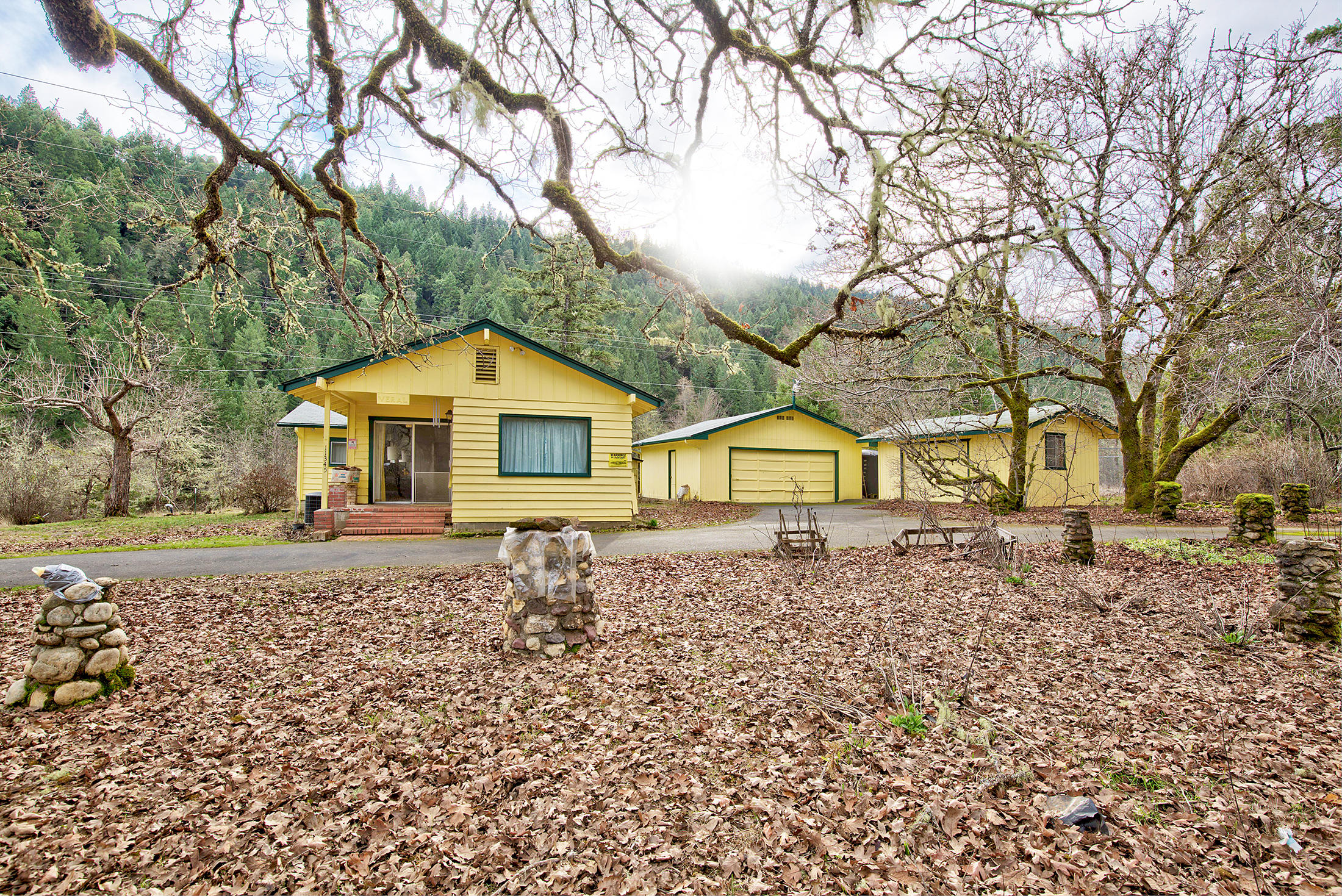Surrounded by trees in the most peaceful of settings you will find this 876 sf traditional style 2 bed/2bath home situated on 31 beautiful acres. The terrain is flat in and around homesite and frontage road, then slopes up the hillside on the back of the property.  Year round Slate creek runs through the property. A huge 30x50 10' cyclone fenced-in garden area awaits for the avid gardener. Oversized 2-car garage and another workshop/garage for storage, 2,000 gal water holding tank, new heat pump. Woodstove/wood burning fireplace. Buyer to do own due diligence with regard to property use and potential for marketable timber. Property sold AS IS.