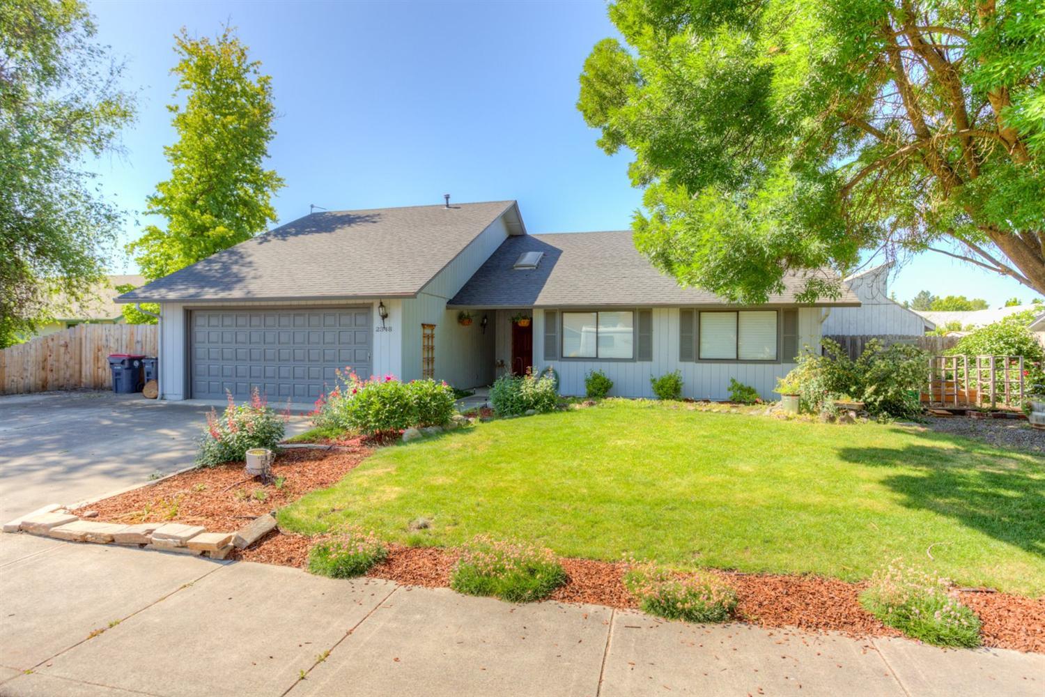 Clean and ready for new owners to call this East Medford house their home! Vaulted floor plan with laminate flooring throughout. Wood burning fireplace, ceiling fan and plant/decorative shelves in great room. Formal dining room open to kitchen with slider to covered patio. Modernized kitchen offers tile counters and backsplash, eating bar, range/oven and dishwasher. Ceiling fan and walk-in closet in master bedroom. Cultured marble vanities and tile flooring in bathrooms. Spacious back yard - swing set included. Storage shed - used to be used as office. Two car attached garage plus great RV parking.