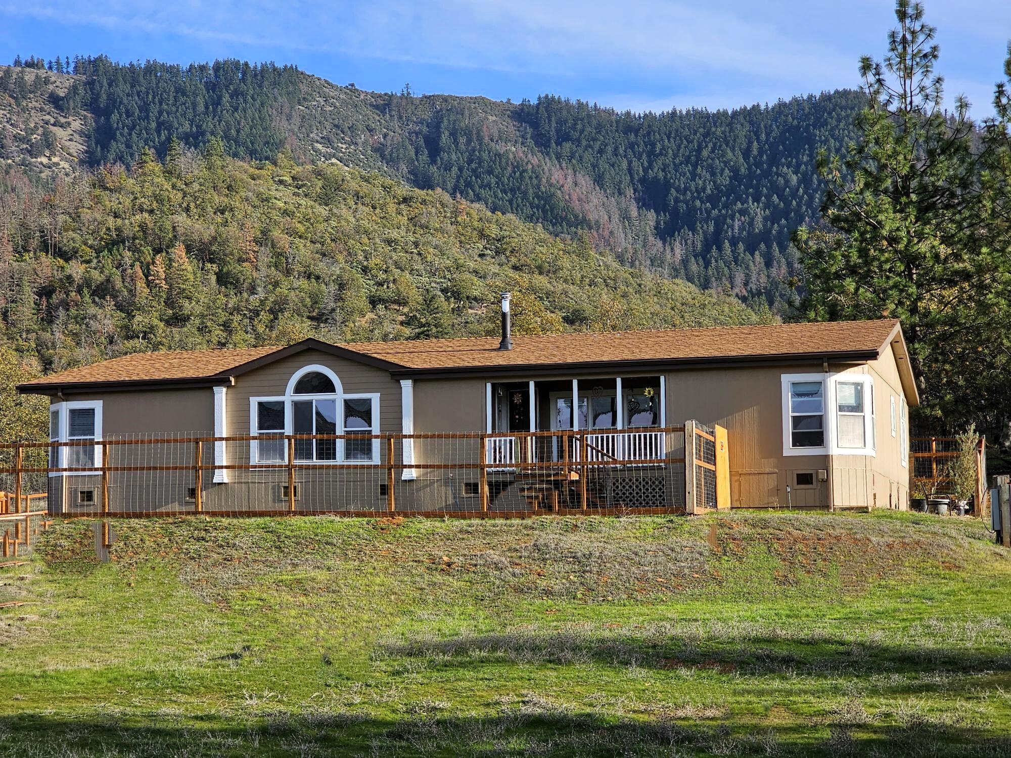Enjoy the gorgeous views of the surrounding mountains and trees with 39.78 private and useable acres,with a 2640sf triple wide home featuring 3bed/2.5baths of a bright & open  floorplan.The kitchen and dining areas are big for entertaining. The main living room offers vaulted ceilings and lg picture windows for enjoying the expansive views. An adjoining den area allows for extra living space. Split floor plan gives privacy to the large main bedroom w/ walk in closet and att. bath with jetted tub, dbl sinks and shower.There is a large 30x50 metal workshop/storage area. RV hookups.Partial fenced land with a two stall horse barn. Incl. in sale is a 1998 ''New Holland'' tractor and implements. Property backs up to BLM on one side, a lovely  vineyard on the other, & it is located near a paragliders launch site! Well is 15 GPM per '22 rpt. Property sits nicely off the main road but it's close to shopping, restaurants, wineries and downtown J-ville, and all that it offers! Some ADA access.