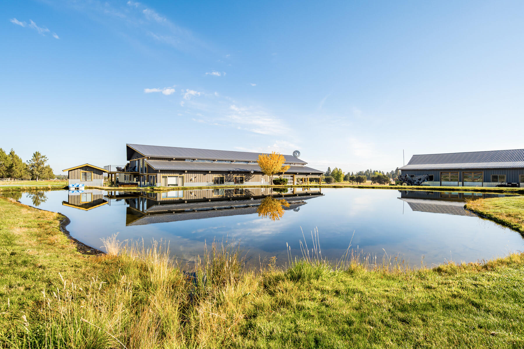 Fantastic barndominium in Tumalo on 19 acres, 17 irrigated and Mountain views. Builder's personal home with the intention of a 3rd bedroom in the future. Attached 72' x 67' garage/shop, 72' x 25' carport/overhang, 6 overhead doors that can accommodate 12+ vehicles. Open beam great room floor plan, center island kitchen, granite counters, full length backsplash, stainless appliances, pantry, breakfast bar, pendant lighting, wood cabinets, wet bar, tile flooring. Distressed solid core wood doors and accents throughout. Floor to ceiling stone fireplace w/wood mantle. Large loft master BR, walk in closet, newly remodeled bath w/custom double headed steam shower, heated tile floors & 14' x 23' Trex deck with mountain & pasture views. Newer metal roof, metal wainscoting, Breckenridge Board & Batts siding within the past 3 years. Full RV hookup, 12'x12' finished & heated pump house, fenced, pond, additional 72' x 54' horse barn, designed for 6 stalls, 72' x 14' lean-to, 5 overhead doors