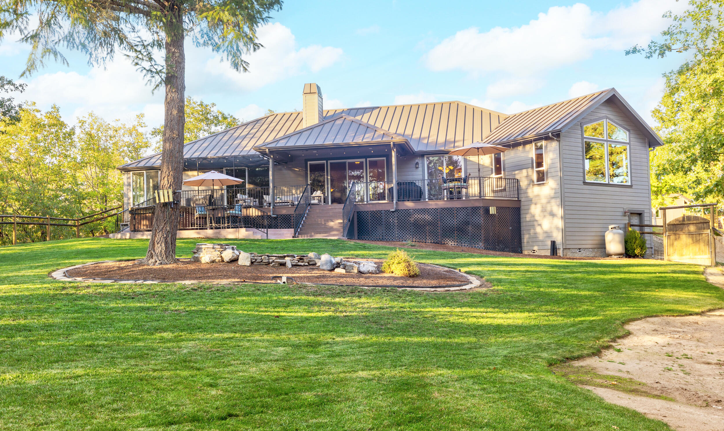 Ultimate Northwest retreat w/privacy, views, stunning 2,911 sq.ft. custom home on 5.04 park-like acres. Designed with intention, welcome to vaulted ceilings, windows that bring the outdoors in, and warm rock fireplace. The chef's kitchen is elegant and functional-granite counters, island w/JennAir cooktop, double ovens. The inviting dining and entertaining areas are perfect for gatherings. Beautiful library/office w/ custom-built-ins provide the ideal spot for work or relaxation. The primary suite is a true retreat-dual walk-in closet, spa-like tub, walk-in shower, and private deck access. Finishes shine-Brazilian Cherry wood floors, 9 ft doors, surround sound, central vac. The finished 2 car garage, 28x28 shop w/half bath, and 50-foot RV garage offer unmatched versatility. Outdoors, enjoy covered decks, hot tub, stamped concrete drive, 25x25 portico, pond w/waterfall, manicured landscaping-the essence of peaceful living. This remarkable property is more than a home, it's a lifestyle.