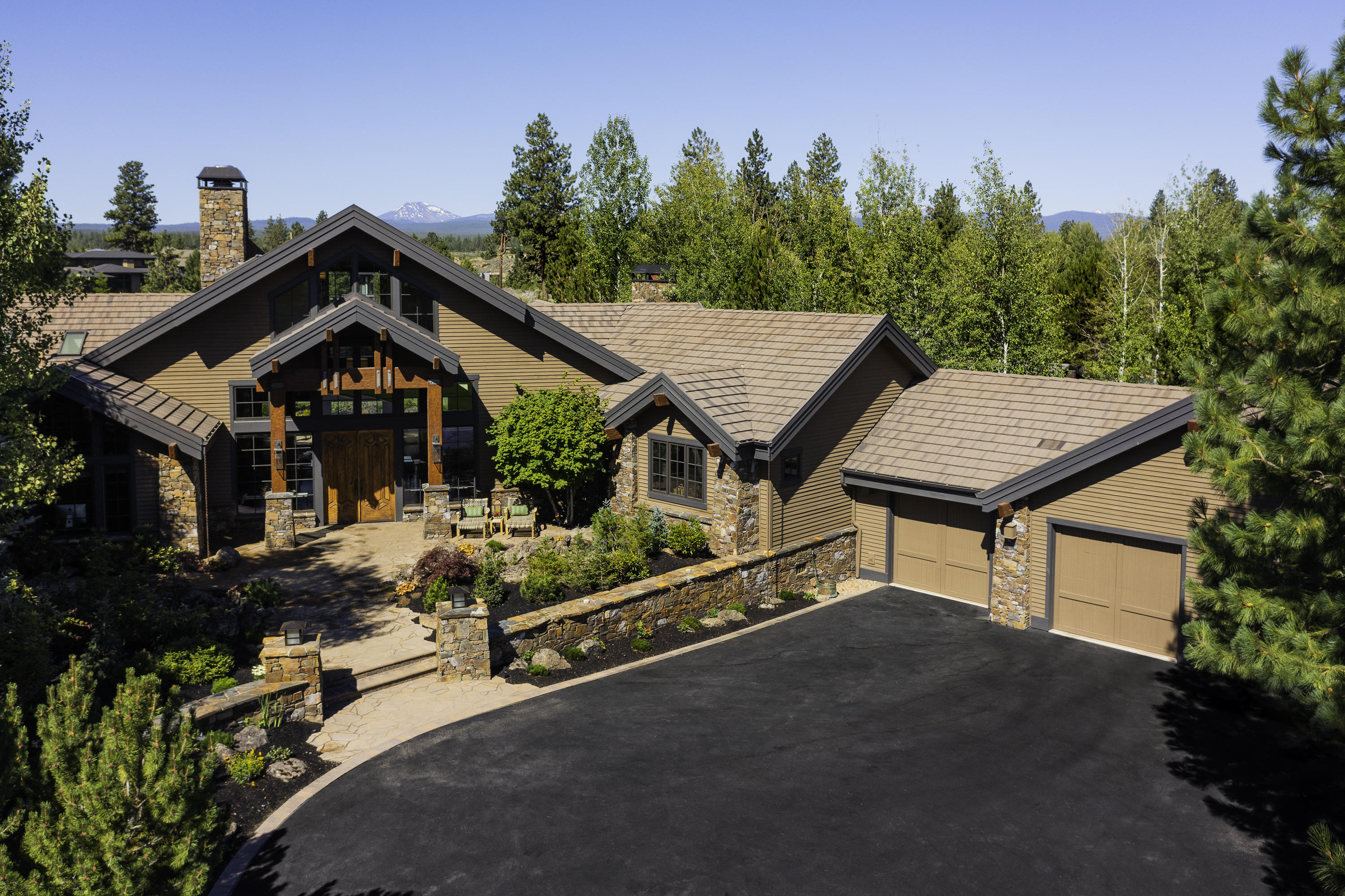 Simply stunning Northwest lodge design in the private, gated Broken Top community on Bend's favored westside & situated on the 6th fairway w/Cascade mountain views. Inviting courtyard entry highlighted by a flowing water feature & stone columns. Beautiful lush landscaping & paver patios. The expansive floorplan is all one level except for an upper level guest suite. The interior craftsmanship is apparent w/hand hewn posts & beams, dovetail & lap joints, hand troweled wall texture & 4 masonry built stone fireplaces. Walls of windows let the natural light shine through. Recently updated w/new gourmet appliances throughout, new ceiling fans & light fixtures, new Hunter Douglas automated shades, new Sonos sound system thru whole house & patio, new Arctic Spa & decking off primary suite. Special features include Elm wood floors, two wet bars, three ensuite bedrooms, back patio with firepit & waterfall, new dual HVAC system with Active Pure air purifier & custom garage cabinetry.