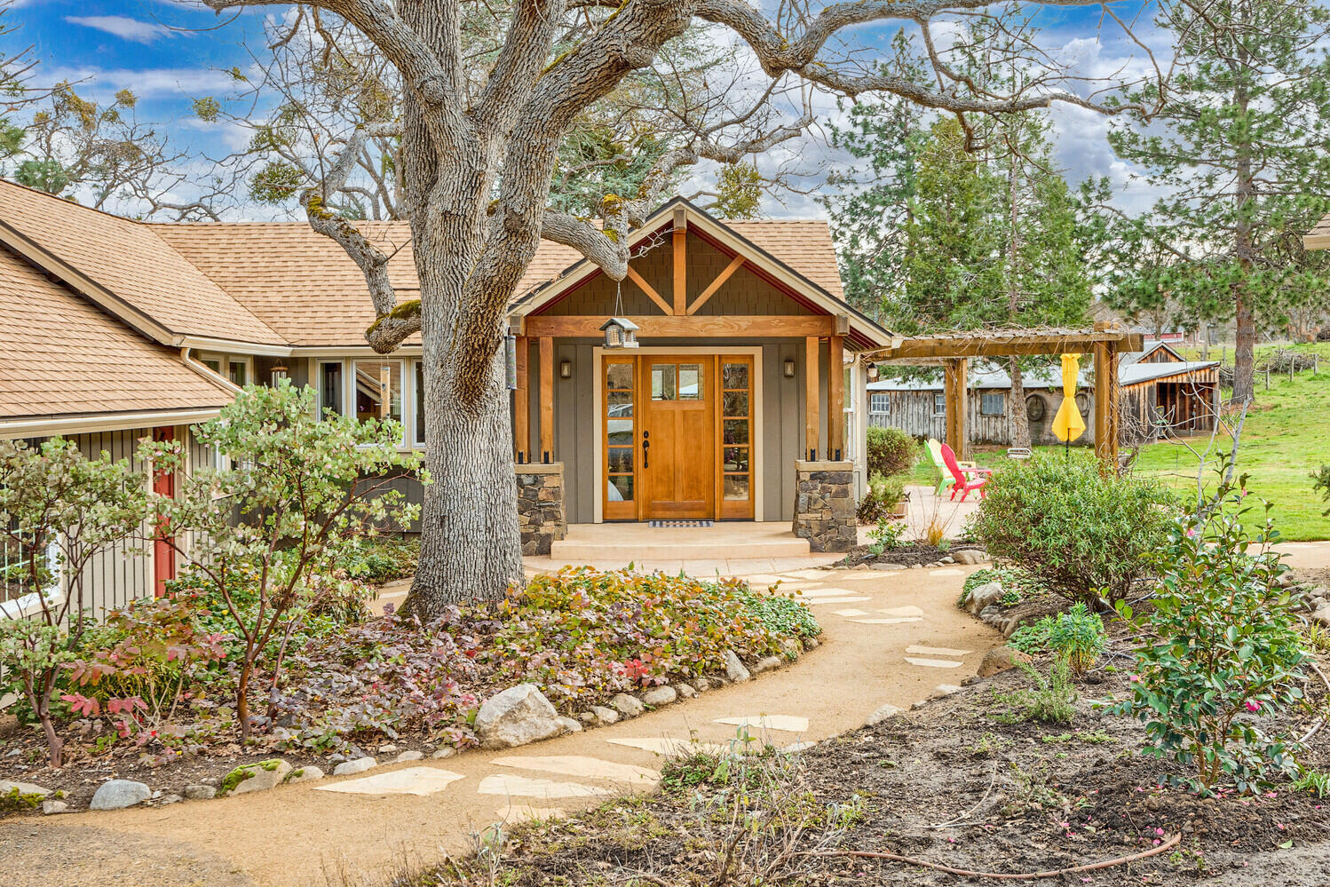 Wonderful, single-level home on over six acres in a highly desired location. With views of the mountains, large pasture, and many recent updates, this home offers so much, yet it is only minutes from Ashland. You will love the open floor plan and ease of living. Hardwood floors tie the living, dining, and kitchen areas together, creating a lovely flow. The open kitchen has custom cabinets and a breakfast bar- perfect for entertaining. The living room has cherry wood built-ins, vaulted ceilings, and a wood-burning stove - a great gathering space. It opens to a deck with a hot tub and mountain views. There are three bedrooms and an office, including a light-filled primary bedroom. Outdoors has garden beds, a sunny, south-facing patio, an apple and pear orchard, 3.7 acres of TID rights, and lots of privacy. Several outbuildings include two barns, a chicken coop, and a canning/potting shed with a solar array. It is a unique property just ten minutes from downtown Ashland.