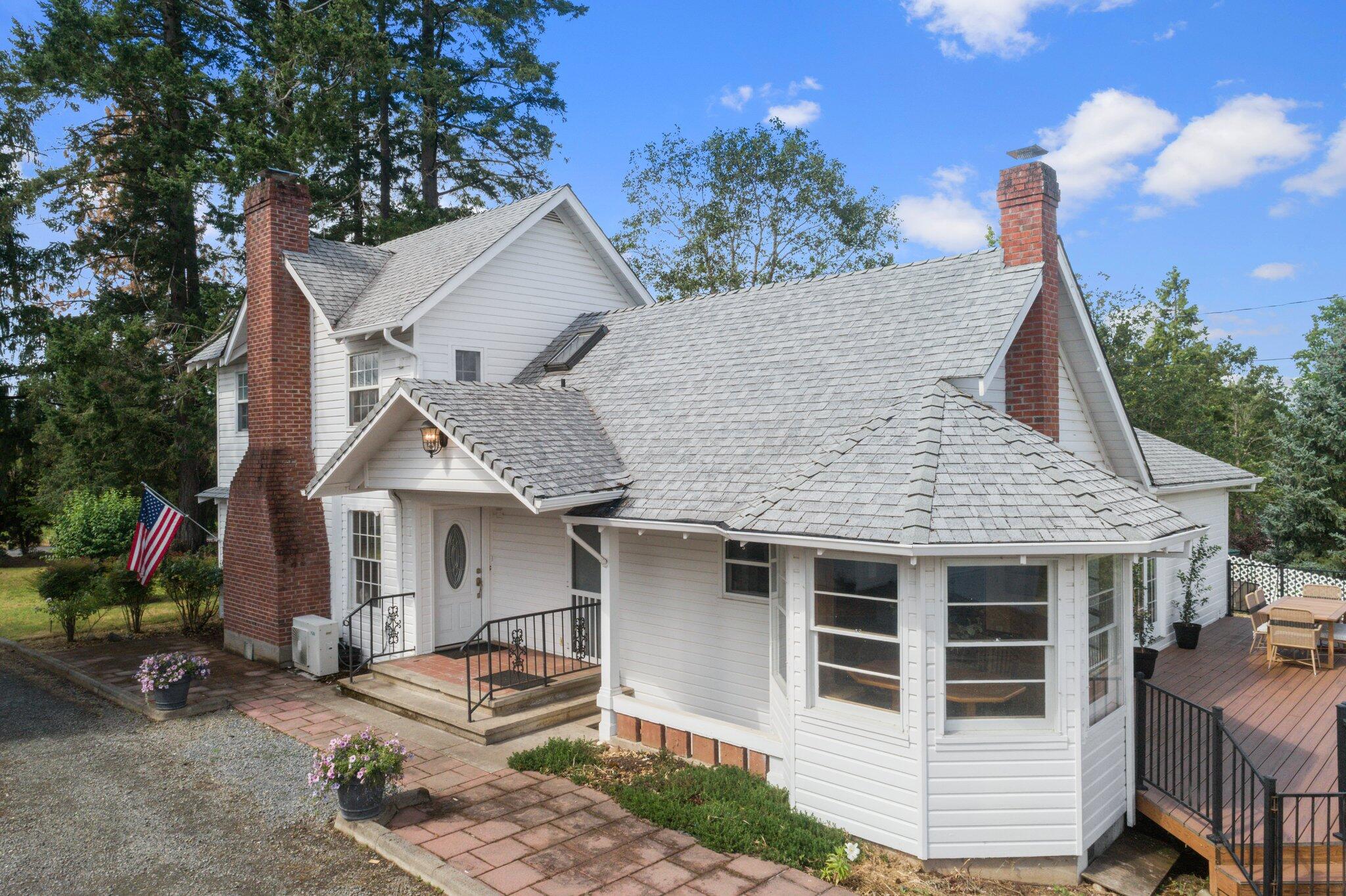 There aren't enough words to describe the charm of this 2-story farmhouse! This property also includes a 1504 sq ft guest house and a separate shop! The main home includes a formal living room designed around the wood burning fireplace, large family room, kitchen with amazing views from the breakfast nook, 4+ bedrooms plus 5 bathrooms and a large basement equipped with its own bathroom! Fresh paint inside and out of all buildings, 2 wells, irrigation rights, open arena for your horse and more! The guest house is the process of being renovated. Buyer has the option of purchasing it finished or having the ability to customize it themselves. Schedule your showing today!