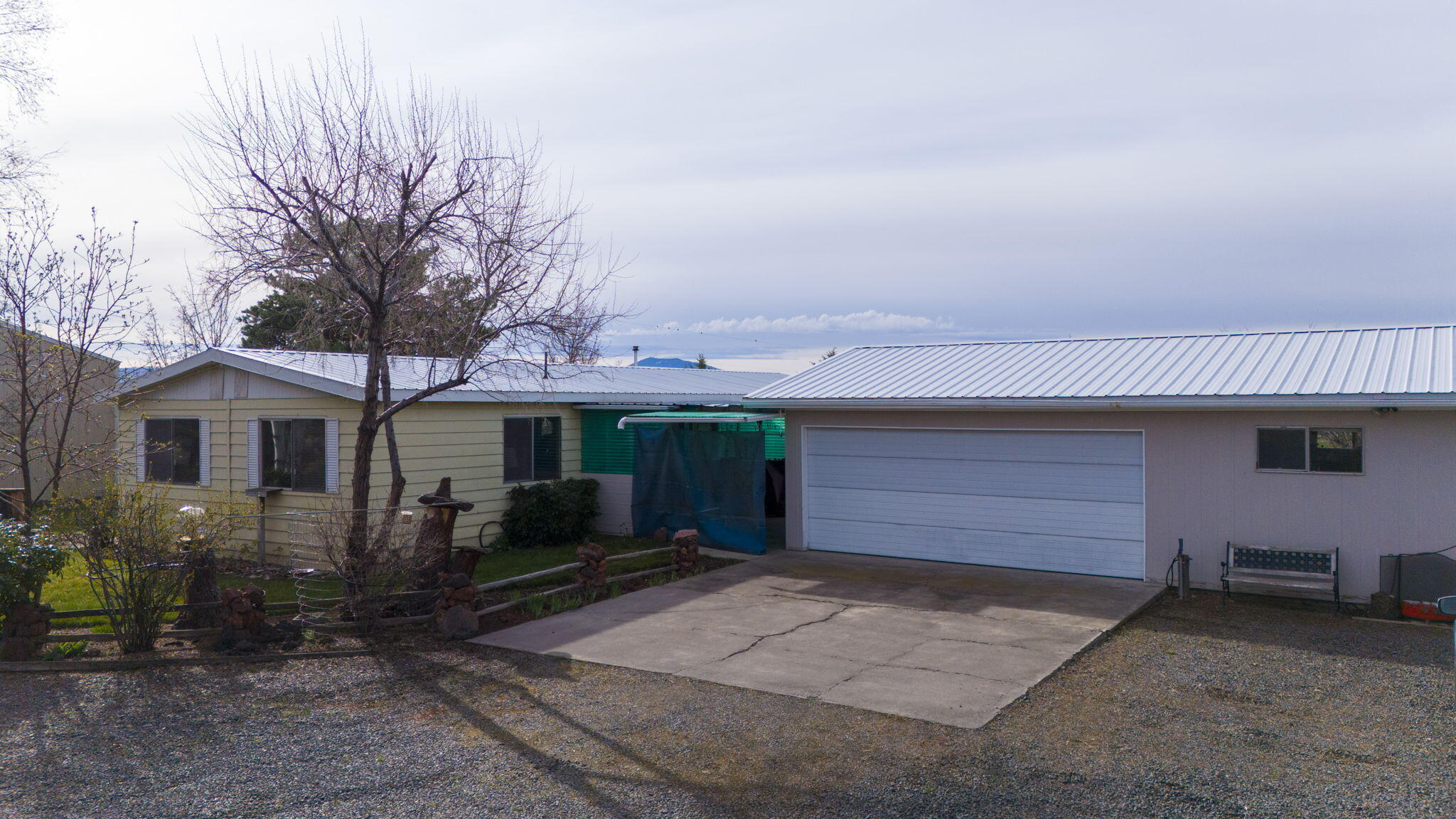 Great one level home on beautiful tucked away 1 acre lot.  Close to town. Home is a 1978 Mfg Home in good condition.  Newer deck. Oversize Double Garage Large Shop.  Living room/Family Room 3 Bedroom 2 Bath home. Great Pellet Stove. Forced air electric furnace.  Hot tub. Partial Mountain Views. Live in the Manufactured home or build on this site.
