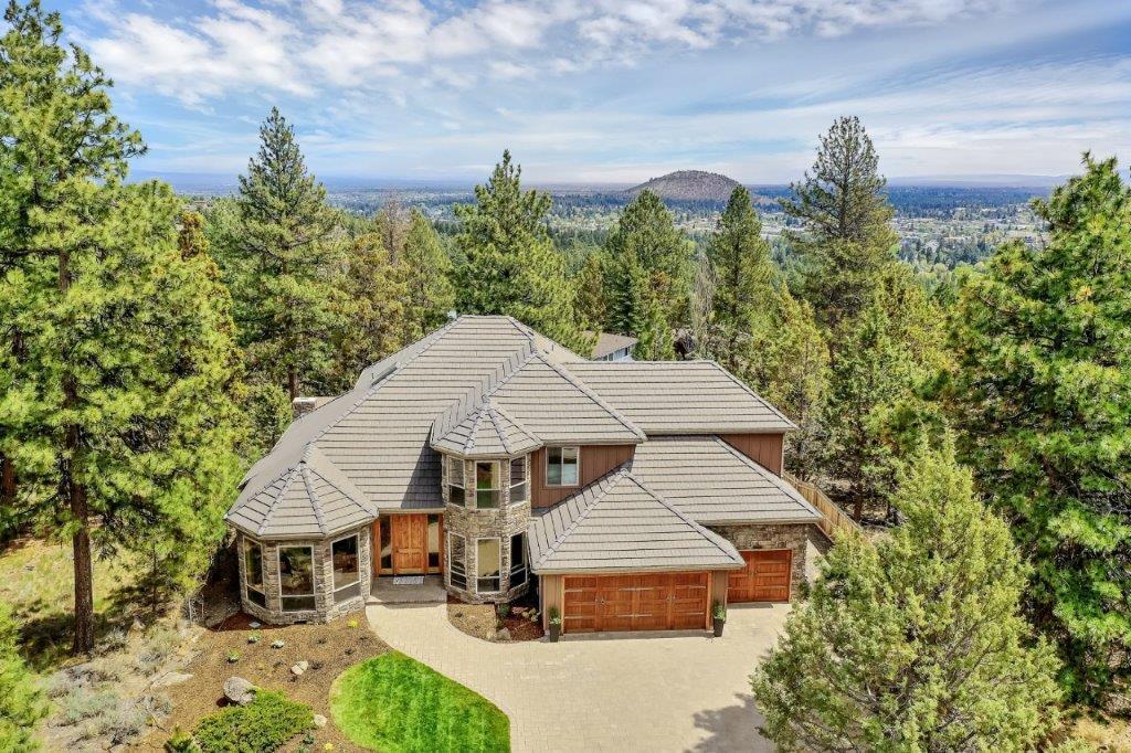 Sophisticated architecture and thoughtful design elements come together beautifully in this fabulous estate perched at the top of West Hills. This home has the perfect layout, where open, yet delineated rooms blend together effortlessly to create the ideal floor plan. Enter the sun-soaked foyer, greeted by cathedral ceilings and warm wood accents. Two handsome natural stone fireplaces highlight the living and family rooms, along with dramatic 9' bay windows. Entertaining is simple thanks to a fully appointed Chef's kitchen with Thermador range, double ovens, beverage cooler, Sub-zero fridge, granite island, and multiple areas inside and out to savor meals. Head upstairs and take in the expansive views from east to west in the sunlit bonus room. Wind down the days in front of the gorgeous, outdoor wood burning fireplace, relaxing under the pines. Purchase the .26 acre vacant lot behind this home for ultimate privacy or build a guest home!