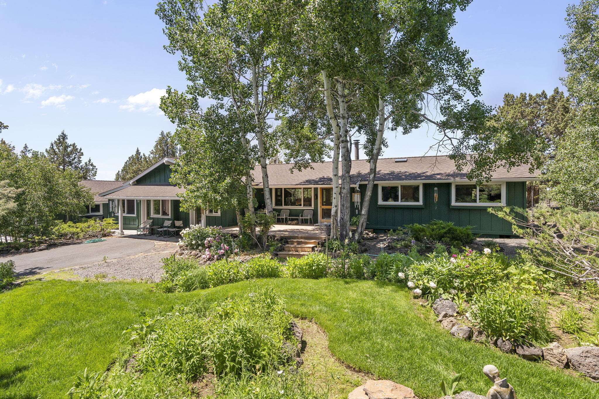A hobby farmer's dream in Bend's coveted Conestoga Hills! This one-of-a-kind single level 4-bed, 3-bath home on 2.15 gated, fenced, and cross-fenced acres offers luxury living with rural charm. Inside, high-end craftsmanship shines with custom wood ceilings and floors, detailed molding, built-ins in every room, and a stunning rock fireplace with handmade ironwork. The chef's kitchen features stainless steel counters, butcherblock, and premium appliances. Indulge in a marble bathroom with heated floors. A private guest suite with its own entrance and full bath adds flexibility. Outdoors, the property is an oasis: lush landscaping with rock pathways, a tranquil pond water feature, and a firepit gathering space. Hobby farmers will appreciate the two high-end chicken coops, the oversized detached garage, multiple outbuildings for workshops and storage, and a beautiful custom wood-framed greenhouse ready for year-round growing. Refined, functional, and truly one-of-a-kind. A must see!