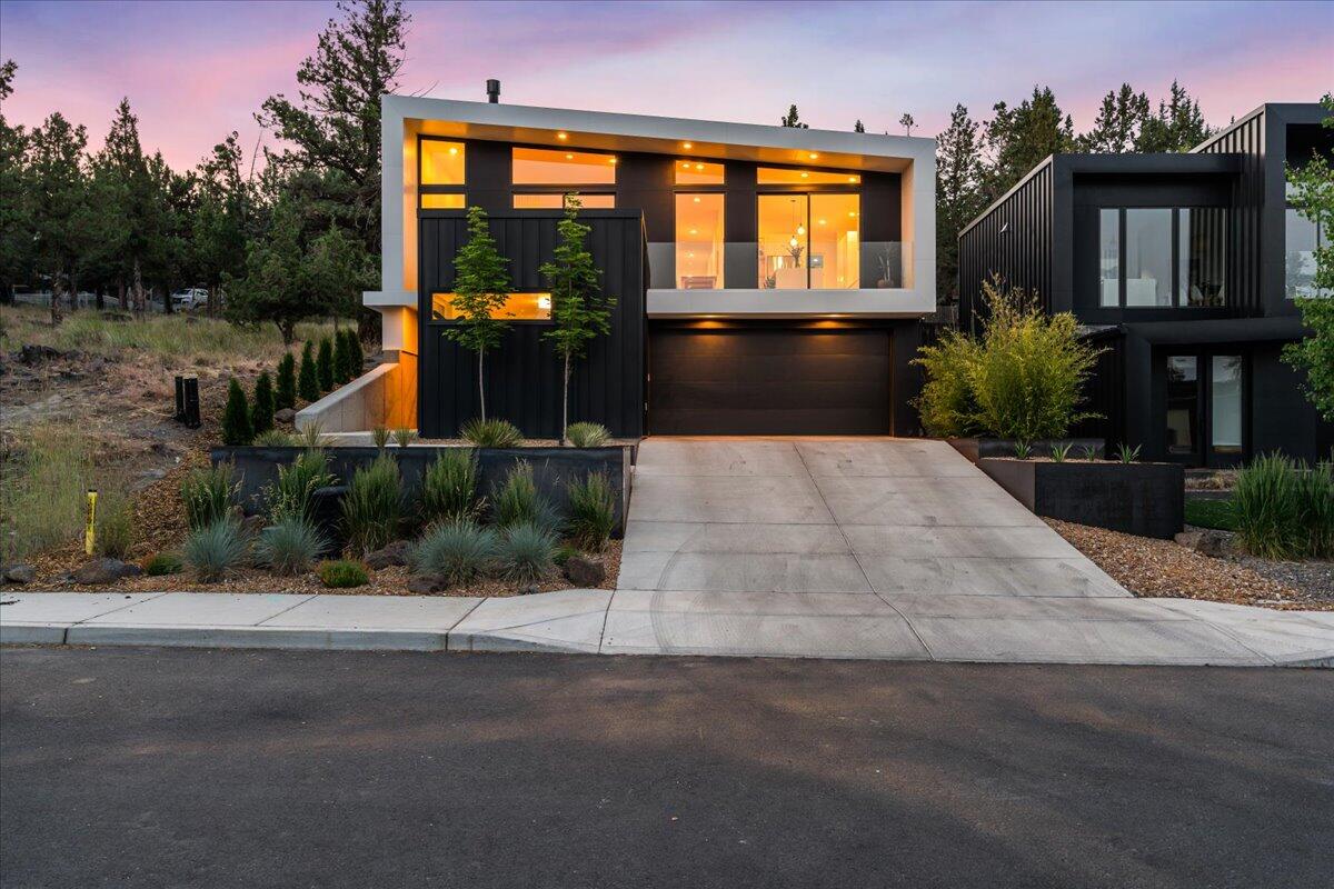Step inside this thoughtfully designed modern home where clean lines, warm materials, and abundant natural light create a bright and inviting atmosphere. The open-concept interior features hardwood floors, a striking Malm Zircon gas fireplace, a sleek kitchen outfitted with Bosch appliances, quartz countertops, glass-front cabinets with white oak shelving, and a wine fridge. The spacious layout includes a luxurious primary suite with a spa-inspired wet room and dual-head shower, as well as three additional bedrooms—one of which is ensuite, making it ideal for a guest retreat, fitness room, or  private office. Step outside to enjoy views of Pilot Butte from the front Ipe wood deck, or relax in the private enclosed courtyard. The fenced and private xeriscaped backyard is a low-maintenance oasis perfect for entertaining. This exceptional home is set on a quiet street, walkable to downtown Bend, the Galveston corridor, and some of the city's best restaurants, coffee shops and boutiques.