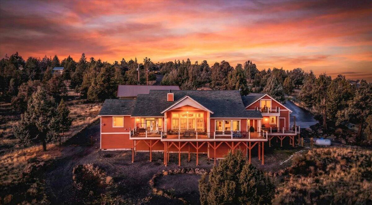 Experience exceptional luxury near the top of Long Butte on this ultra-private 2.66-acre estate with sweeping views from Smith Rock to Paulina Mountains. Minutes from Hwy 97, Target, Costco, & The Bite, this low maintenance property is being offered w/ALL possessions throughout included in the sale or they can all be removed; high-end décor & furniture, premium appliances, patio furniture, fire pits, backup generators, too much to list! Main-level living offers a massive vaulted great room, an office, a gourmet kitchen w/pro-grade SS appliances, dual ovens, a large island, and farmhouse sinks throughout. The spacious vaulted primary suite features a tiled shower, jetted tub, deck access, & an enormous walk-in closet. Enjoy a 1,100-sf wraparound deck w/covered awning, BBQ & Smoker. The fenced, gated property provides ample space for toys, including an attached garage & a 48x24 motorhome garage/shop with a full-length lean-to. Prime Airbnb potential. Don't miss this great opportunity!