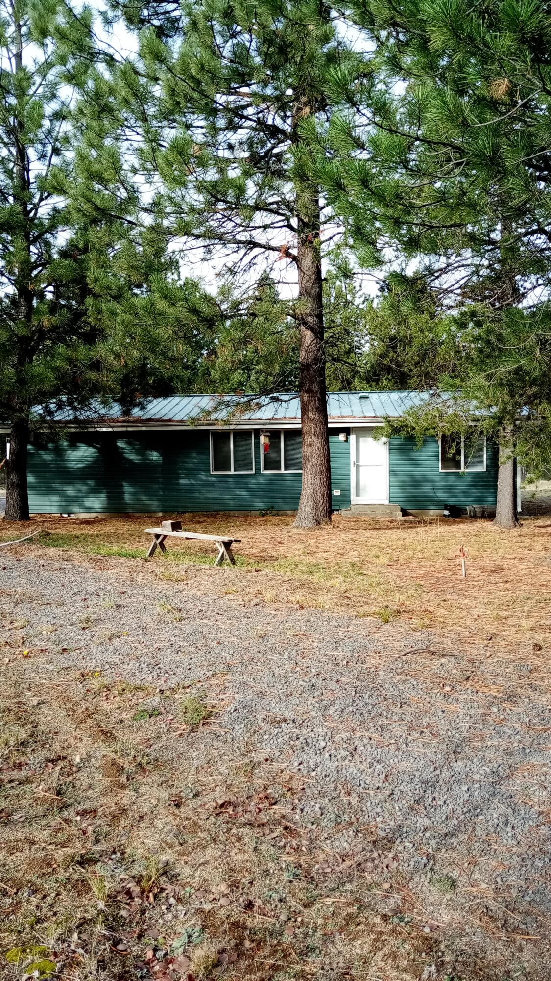 Price reduction, don't miss this sweet home.  Imagine stepping into immediate tranquility with this move-in ready haven, perfectly situated on a fenced and gated one-acre lot. The garage/shop is an open canvas, eagerly awaiting your dreams—be it a dedicated craft workshop, a lively band room, or the ultimate 'cave.' Outside, an established greenhouse, ready garden space, chicken coop, and metal-roofed home offer a self-sustaining lifestyle ready for immediate enjoyment. With a circular drive, ample natural light streaming through the windows, and an efficient floor plan featuring a handy laundry/mud room, this property is poised to be the comforting, creative retreat you've always desired. Make this your home TODAY!