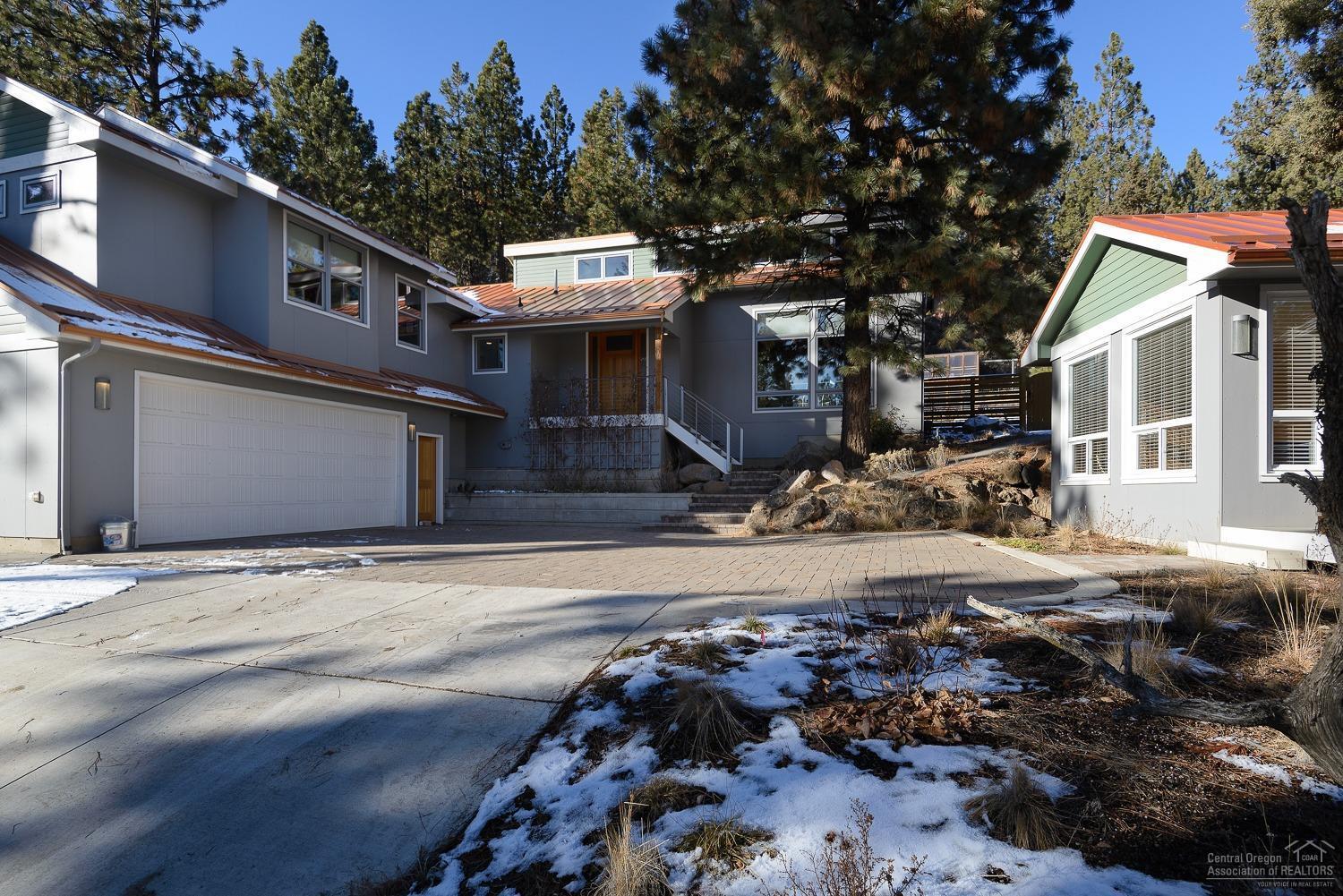 Your Bend lifestyle is calling! Beautiful custom home w/ ADU and transferable STR permit, located on the way to Mt. Bachelor. Close to skiing, hiking/biking trails, lakes, Deschutes River, downtown & Old Mill. This home features sustainable & environmental building products including countertops, floors & carpet. The Great Room floor plan features vaulted ceilings w/ architectural wood beams, hardwood floors & large custom wood windows. Chefs kitchen w/ 6-burner Wolf range, steam oven & Paperstone counter tops. Plenty of space to enjoy outdoor entertaining on the spacious paver patio w/ views of the boulder outcroppings. The custom built pizza oven will be a hit w/ friends & family and after a day of skiing relax in the generous sized hot tub. Grow your own veggies in the greenhouse & raised beds. The ADU w/ dedicated parking space is a permitted vacation rental & is finished in the same quality materials as the main home. The oversized 2-car garage has room for bikes, skis & more!