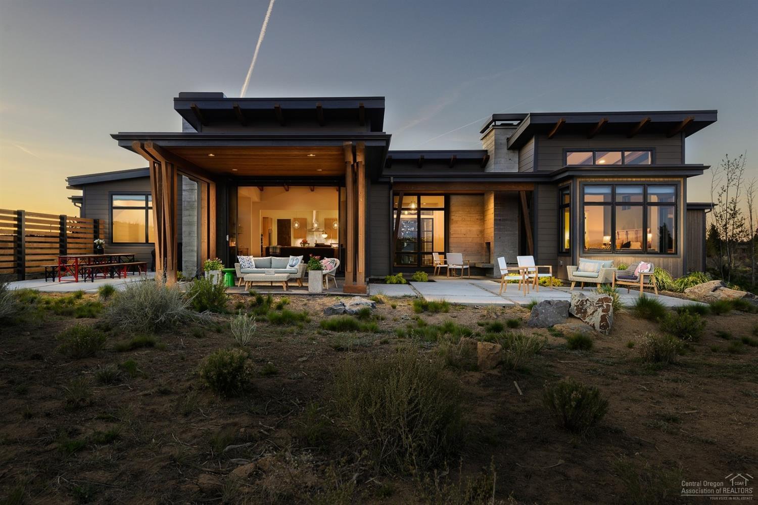 Breathtaking Bachelor and Tetherow views, birds chirping, high desert landscape, and the big Bend sky are just a few natural elements to be enjoyed from back of this unique property in Tartan Druim. Situated on close to an acre, this absolutely stunning custom contemporary single level home features exposed beams, structural board form concrete, metal shed roofing, two wood burning fireplaces, la cantina style doors, split oak cabinets, hand scraped white oak floors, Rejuvenation lighting, and so much more. With 3 bedrooms, 3.5 baths and office inside the main home & an additional casita w/full bath, the property offers function for many types of households. Plenty of storage with 3 car garage and a large mud/utility room, A/C and many windows to soak in natural light are of some of the additional interior amenities. Outside spaces include a crushed granite approach perfect for cornhole or bocce, picnic and bbq area in back, outdoor fireplace and multiple seating areas. One of a kind!