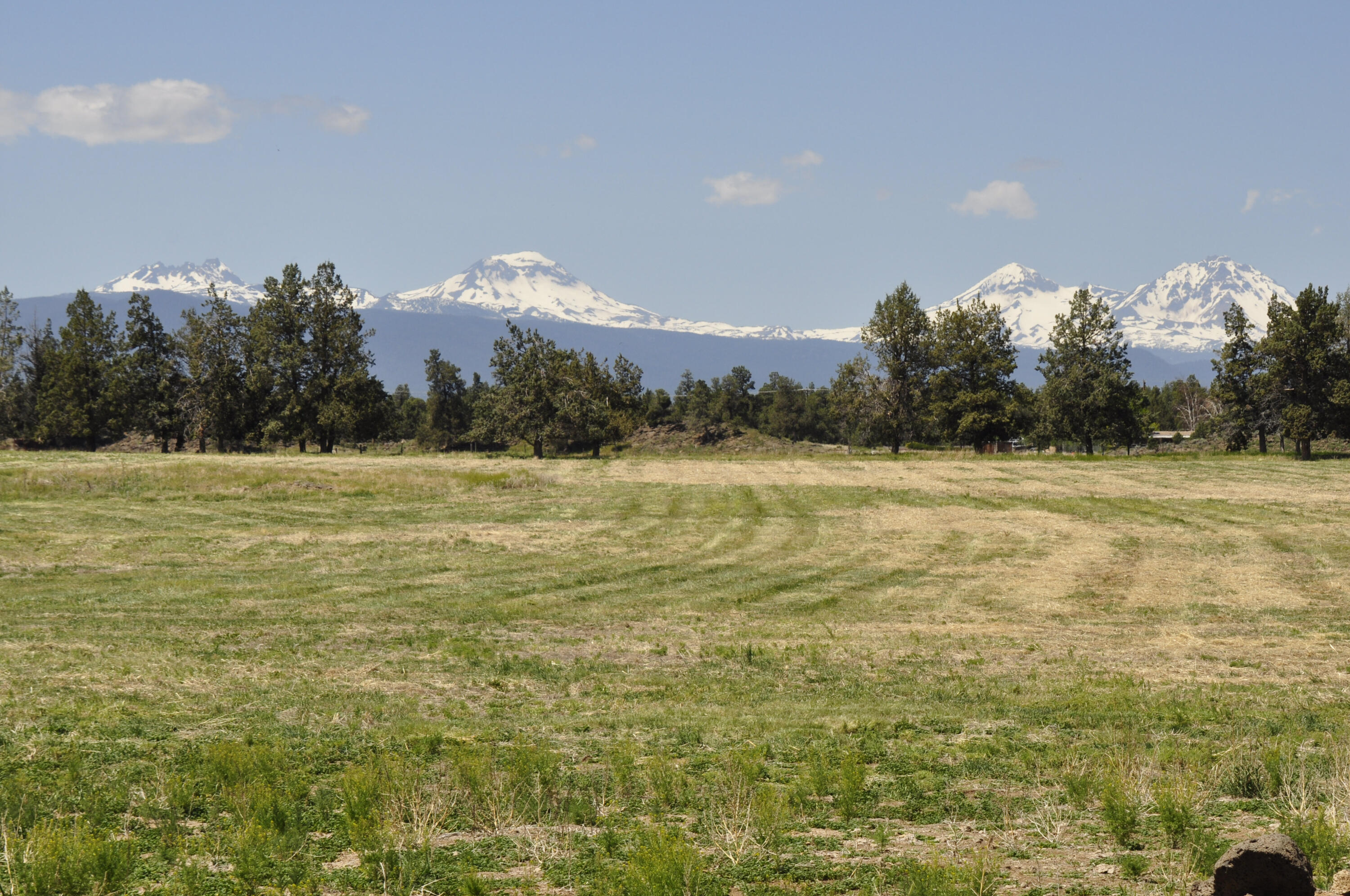 Rare large vacant acreage consisting of two legal lots of record in the desirable NE area of Bend, conveniently located within short driving distance of Bend, Tumalo and Redmond. +/- 68.24 ac and +/- 5.48 ac with COI water rights of 54.2 ac and 2.8 ac respectively. The east boundary of the parcel abuts a very large block of public land expanding your recreational activities right out the back door. These properties have been under the same ownership for over forty years and used as a cattle ranch. Big Cascade Mountain views from the elevated rock outcroppings on the east end of the property with several nice potential building sites. Buyer to do their due diligence regarding any/all land use like CUP's, land division, and water rights. Property has most of the perimeter fenced however the fence lines may not be on the property boundaries.  Newer 3000 sf steel beam hay/equipment barn.