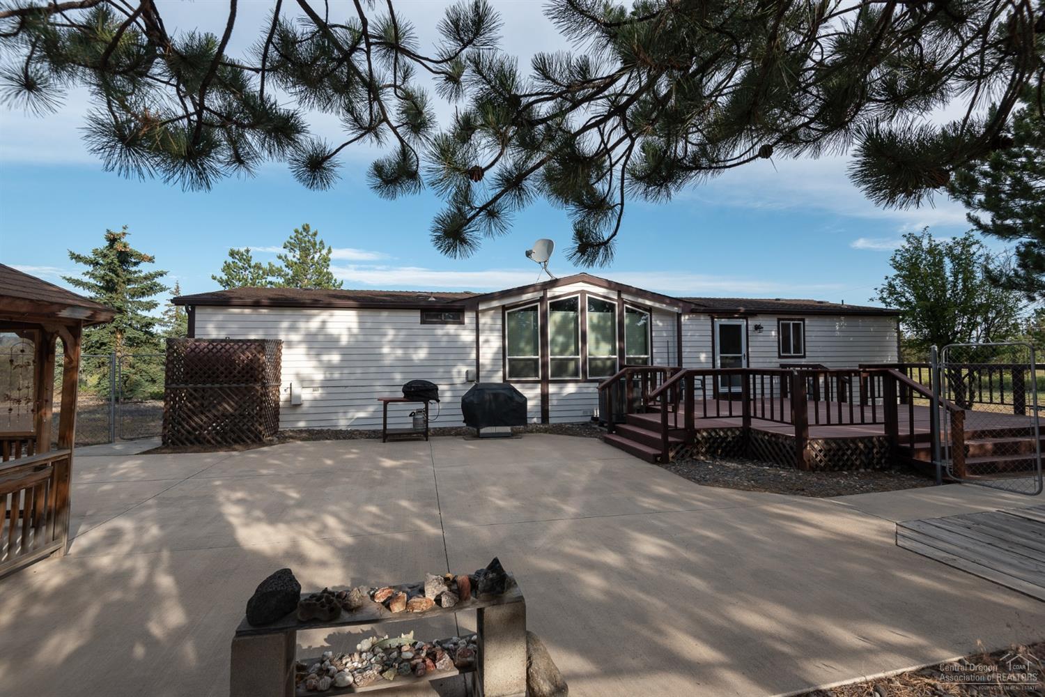 Exceptional Pride in ownership, Located just outside of Bend city limits. 2.51 acre property is fenced, cross fenced for animals, garden area with water, Storage shed, 72x30 ft combined Garage, shop, woodworking shop area, plus storage. 1989 Manufactured home been extremely well cared for inside and out. 2114 s.f. 3 bedroom with den office area, with open vaulted light and bright living area. Heat pump and monitor oil heat. Kitchen with great storage and counter space. Breakfast nook dining area, and separate formal dining. A large utility room with storage and sink, back deck access. Master bedroom separated from guest bedrooms. Large outdoor patio is enclosed with fencing, gazebo. Gated -tree lined drive, natural landscaping, mountain views from property, Located conveniently between Bend, Redmond, Tumalo. Bring your toys, kids and animals and make this your new home.