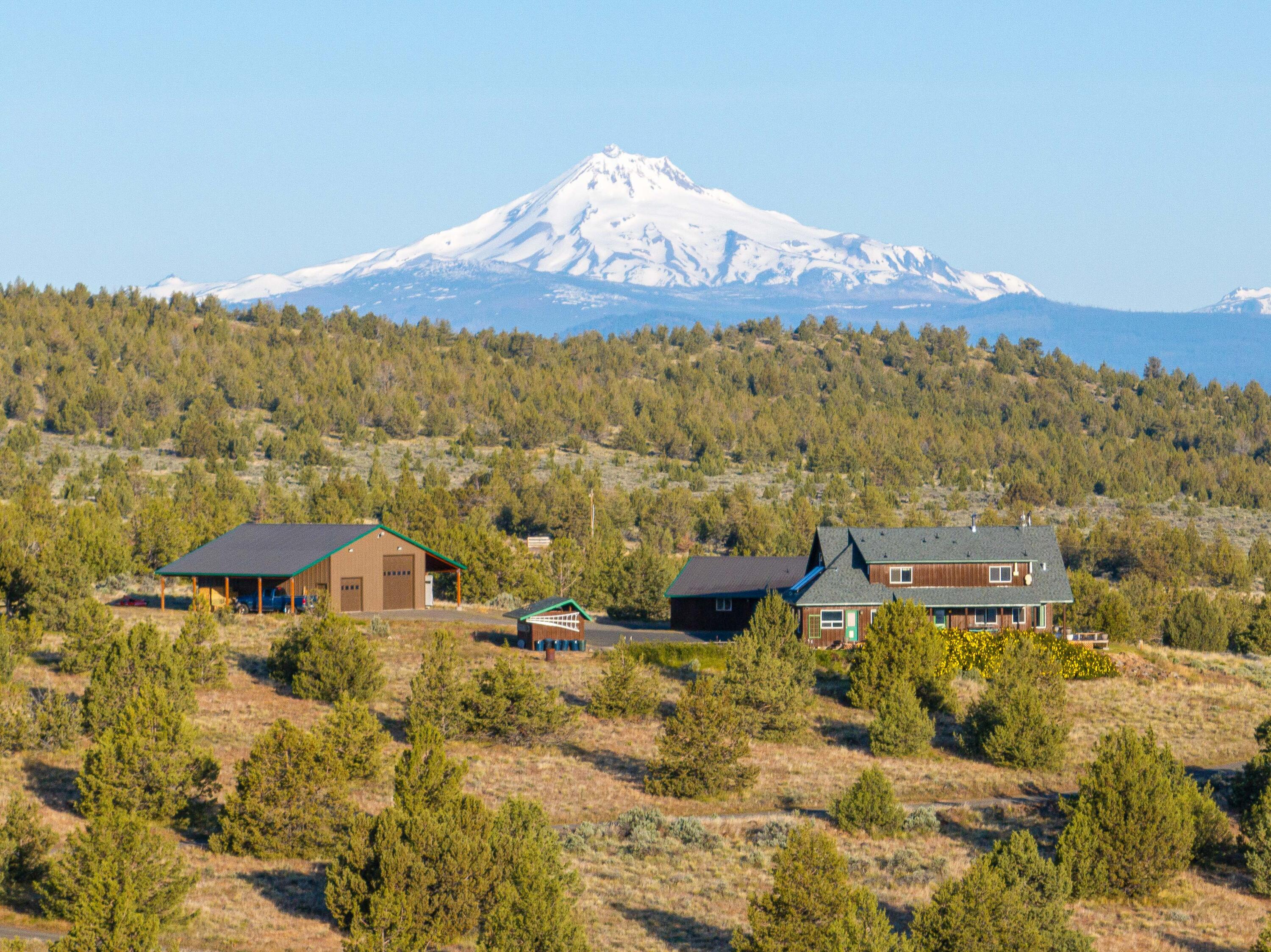 Looking for privacy without sacrificing convenience? This stunning 79-acre estate offers the best of both worlds—seclusion and sweeping views, just minutes from town. Surrounded by open grasslands and bordered by National Forest, this one-of-a-kind property features a beautifully crafted 2,900 sq ft home with 3 bedrooms, 2.5 bathrooms, an office, and a versatile bonus room that can serve as a 4th bedroom. Enjoy panoramic 360-degree views from every window.

A detached two-car garage includes a charming guest house—perfect for visitors or multi-generational living. The property also boasts a large RV garage/shop, fully insulated with a 50-amp hookup, concrete floors, and a durable metal roof—ideal for storing all your Central Oregon adventure gear.

Lovingly built and meticulously maintained, this home offers the peace and space you've been dreaming of, all within easy reach of town amenities. Don't miss this unique opportunity to live your Central Oregon dream!