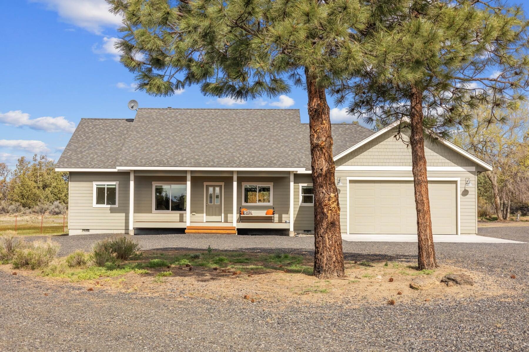 Surrounded by hundreds of acres of BLM on two sides, privacy is paramount in this setting. 7.69 acres of fenced pasture, w/ 7 acres irrigated, gaze upon Cascade mountain views from the comfort of this immaculate home. Thoughtful separation of primary from guest rooms, 3/4'' white oak hardwood floors, complemented by quartz countertops and knotty hickory cabinets throughout. The home is engineered for a two-story addition, if desired. For those w/ outdoor toys, the oversized garage has a 9 1/2' door w/ 528-square-foot space above the garage w/ water connections & is accessed via an electronic stairway. The space is ready for your customization. Forced air heating and a 3-ton heat pump, can be controlled via WiFi. Two electrical services—one 400-amp and one 200-amp—along with two separate RV hookups and one blackwater dump allows friends to pull up and stay. Power and water are already stubbed out and conveniently located for someone who wants to build their dream shop.