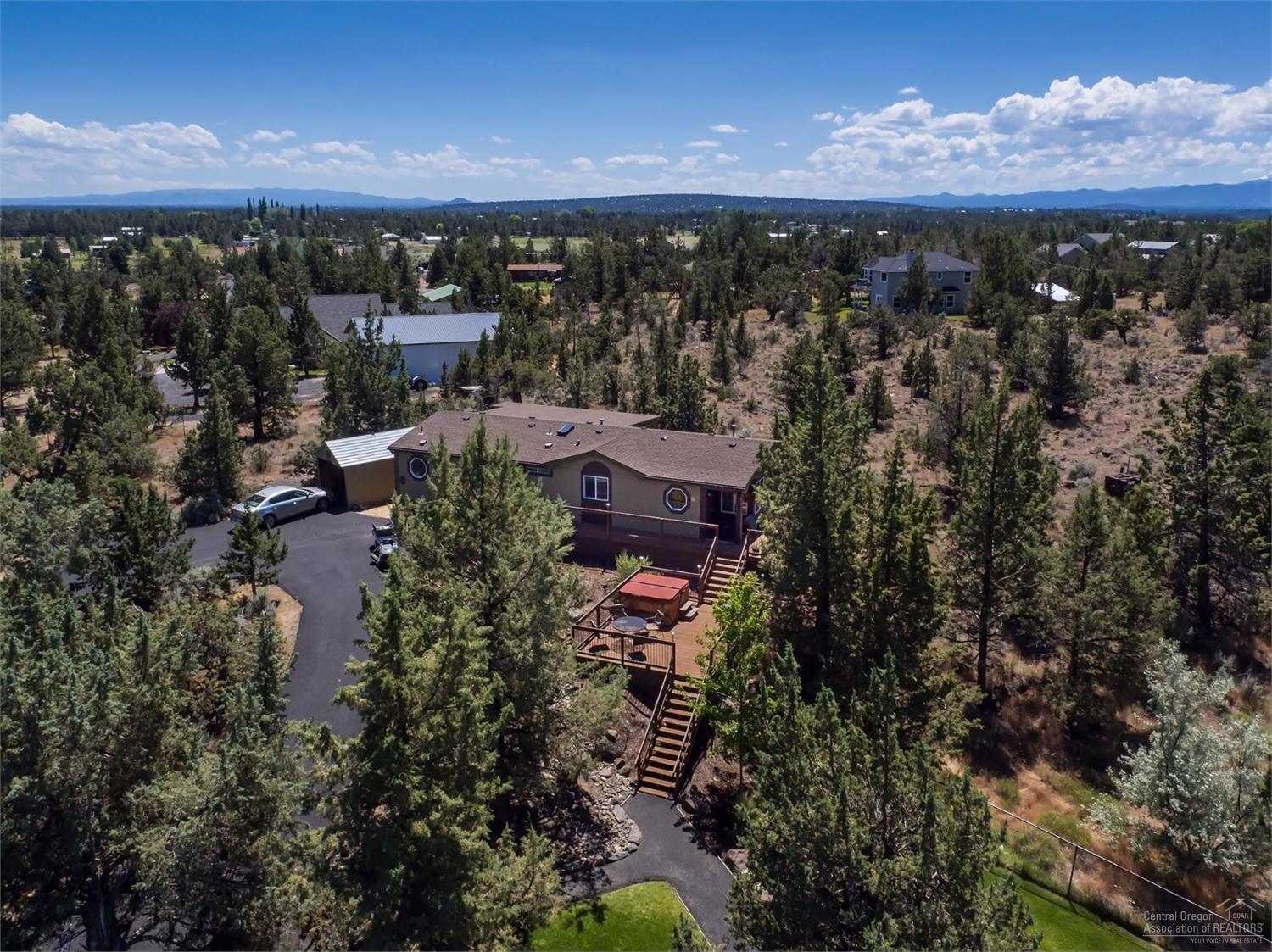 Stunning 3.35 acre home in SW Redmond has it all! This breathtaking property features a paved driveway, large shop lined with cabinets, Alure diamond plated flooring, guest house that is complete with kitchen, laundry room, bath & loft. Large barn with one stall and option for more. Home has been updated with wood flooring, custom lighting, tile throughout, stainless steel appliances, double oven and has vaulted ceilings. Enjoys evenings out by the built in fire pit or on the deck in the hot tub!