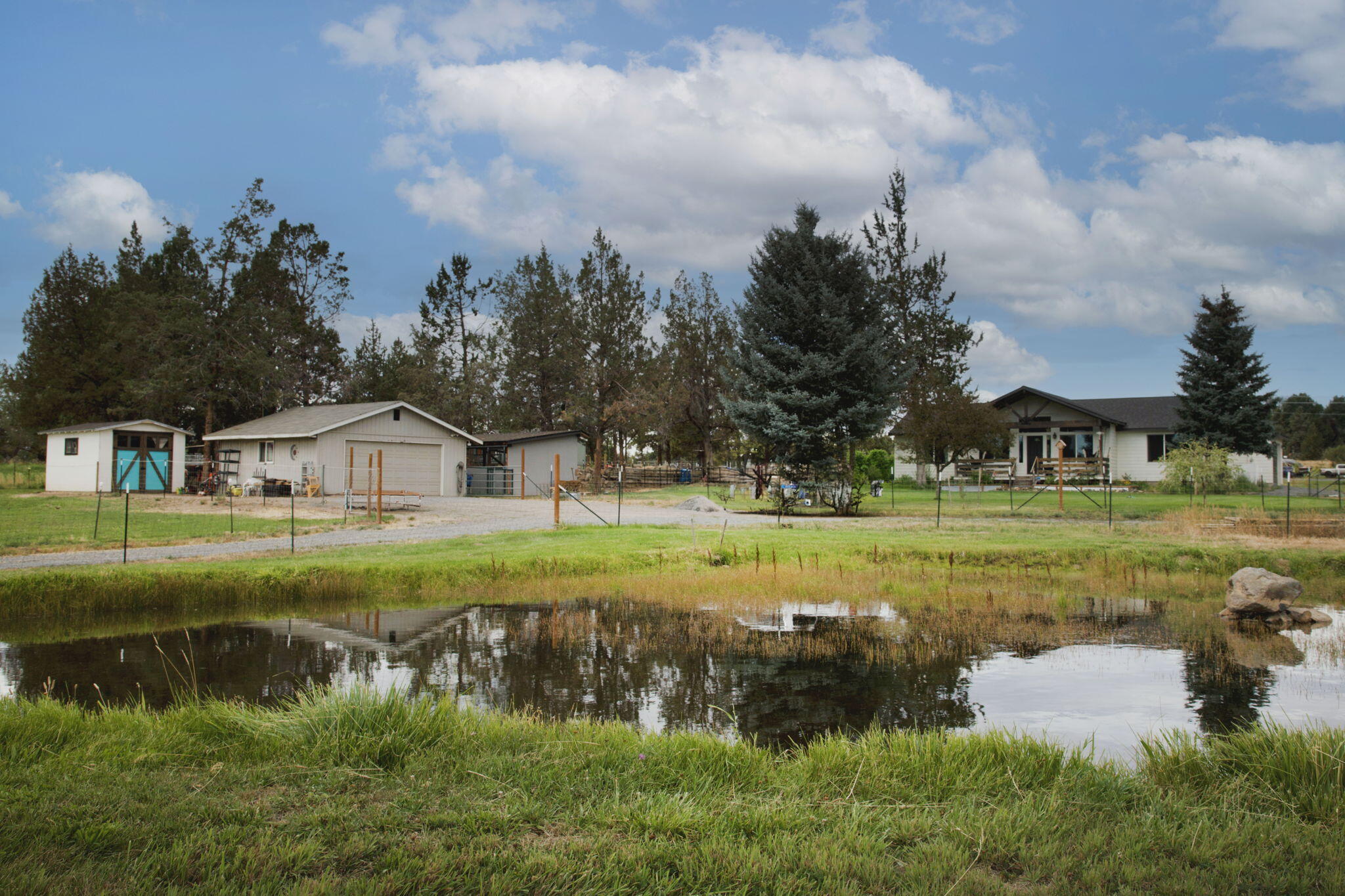 Newer 2020 single-level home on 2.5 irrigated acres with 2 acres of irrigation rights. Light and bright interior with vaulted ceilings, granite counters, great room layout, forced air, heat, and central A/C. Attached 2-car garage plus additional detached 2-car garage, storage shed with concrete floors, outbuildings, and a chicken pen. Horse setup with fenced pasture and two stalls. Centrally located turnkey hobby farm - a must see!