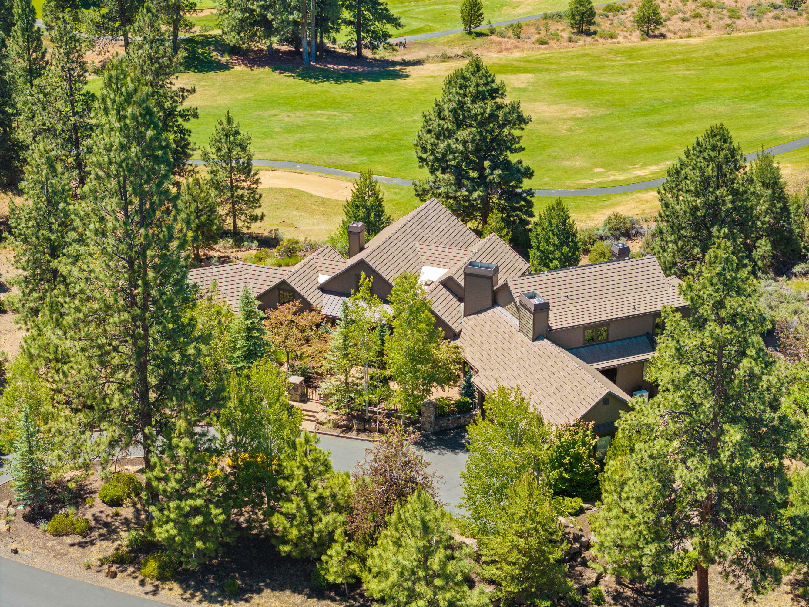 Luxurious home in the gated neighborhood of Sunset View Estates. Backing the 6th fairway of Lost Tracks Golf course. Fabulous setting on a 1.27-acre lot w/Mt. Bachelor & Broken Top views. Built by Artisan Homes and featured on the 2009 Tour of Homes. Gorgeous Timber truss, great room floor plan, spectacular floor to ceiling stone fireplace & walnut log mantle. Knotty alder woodwork, beams, purlins, doors
& trim throughout. Elegant ''cooks favorite'' kitchen offers professional grade appliances, knotty alder cabinets, granite counters, both a 15' and 12' island w/storage on both sides. Travertine tile flooring, walk-in pantry. Large main level primary suite, floor to ceiling tile shower w/river rock accents, jacuzzi tub, 2 walk in closets, dual vanity. Huge family room/loft area, Mt. Views, 3 balconies and big storage room/closet. 2 junior suites with full baths. Downstairs bedroom suite, full bath & separate entrance. Fantastic landscaping w/covered paver stone back patio & courtyard