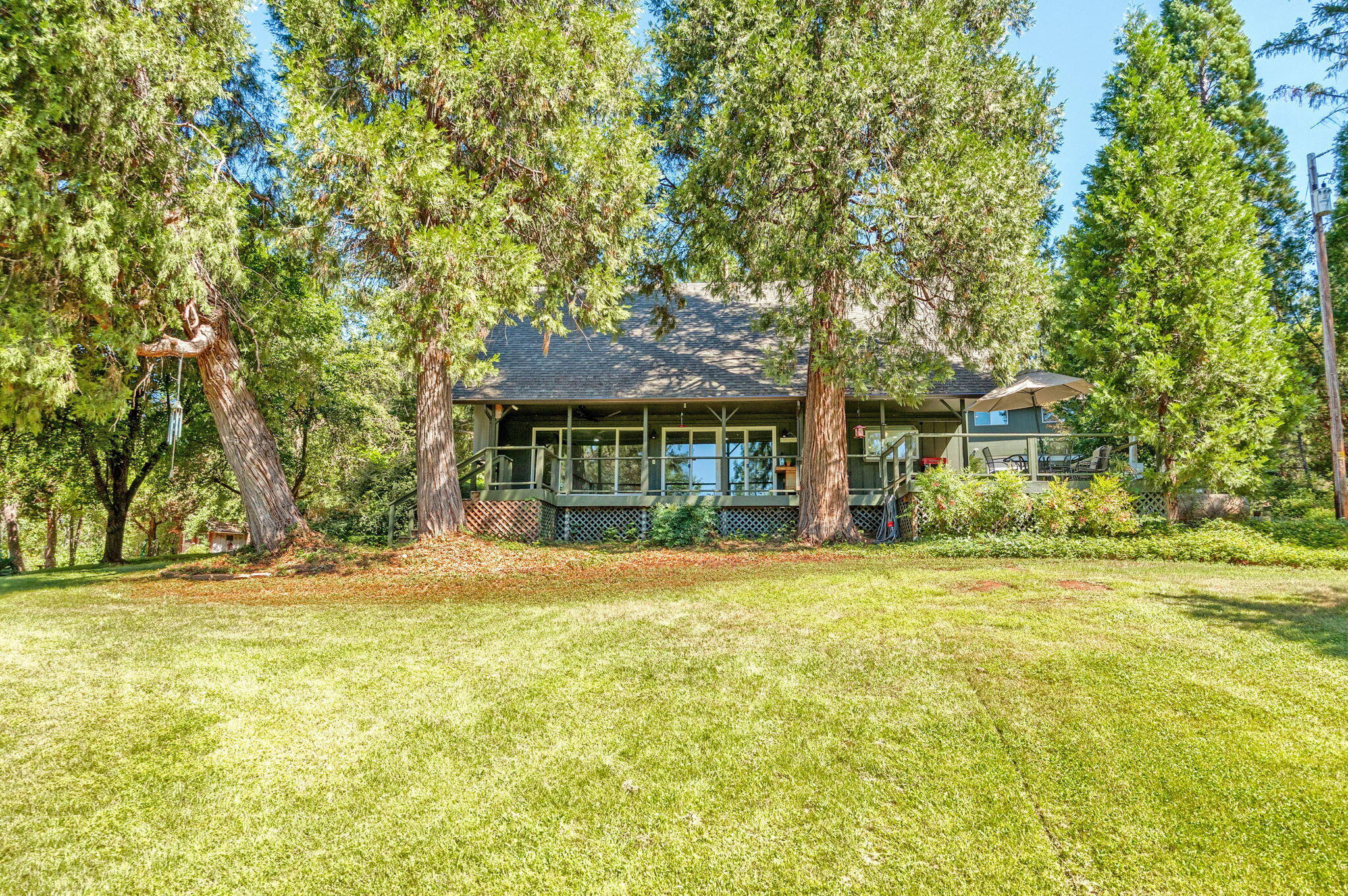 Tastefully updated, this 2 bedroom/2 bath single level home offers tons of versatility. Don't let the room count fool you! There is ample space throughout this open floorplan including a finished attic space perfect for storage or a potential addition. Stunning kitchen remodel with granite counters, tile backsplash + stainless appliances. The primary bedroom offers a beautiful on-suite w/ custom walk-in shower. Floor to ceiling windows in the great room allow for great natural light & beautiful views of the park-like setting. Expansive deck that is partially shaded! Large detached garage + shop w/ additional storage space, room for 3 vehicles + additional laundry hookups. Above the garage you'll find an 864 sq ft guest quarters complete w/ bedroom, kitchenette, bathroom, dining & living area. Multiple outbuildings, garden areas, fruit trees, flowers, a seasonal creek that borders the property + covered RV parking. Land around the home is fenced & offers an electronic gate for entry.