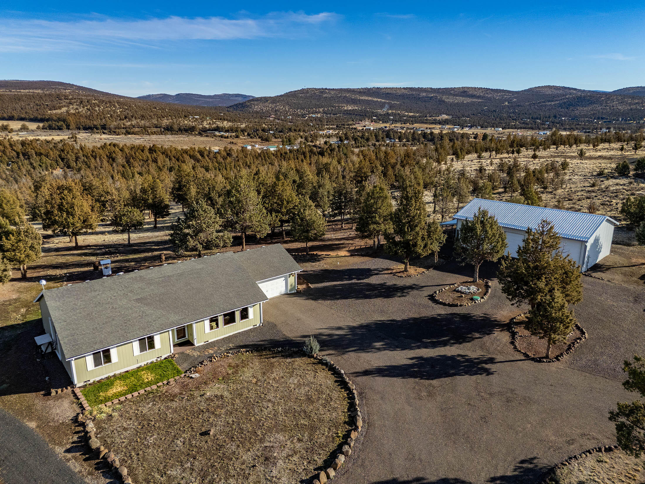 Amazing setting 14.42-acre property off paved road in Ironwood Estates offering a rural feel w/privacy, functionality & breathtaking Cascade Mountain Views. A gated circular driveway welcomes you to ample parking & double attached garage. Well-maintained home built in 2004, 1,704 sqft, 3 bedrooms, 2 bathrooms, & large open kitchen w/ eating bar, nook, & space for formal dining or family room. Enjoy the outdoors on expansive open Trex deck w/ fire pit & stunning snow-capped mountain views. Upgrades include four newer mini-split units & interior/exterior paint. The home also has whole-house ventilation system. Property features a fully insulated 1,500 sqft shop equipped w/ 240 power, half bath, & four spacious bays—perfect for RVs, trailers & all your gear. Additional amenities include a large RV cover w/ concrete foundation, covered dog run & storage shed for added utility. Fully fenced with five separate areas, ideal for horses and outdoor enthusiasts.