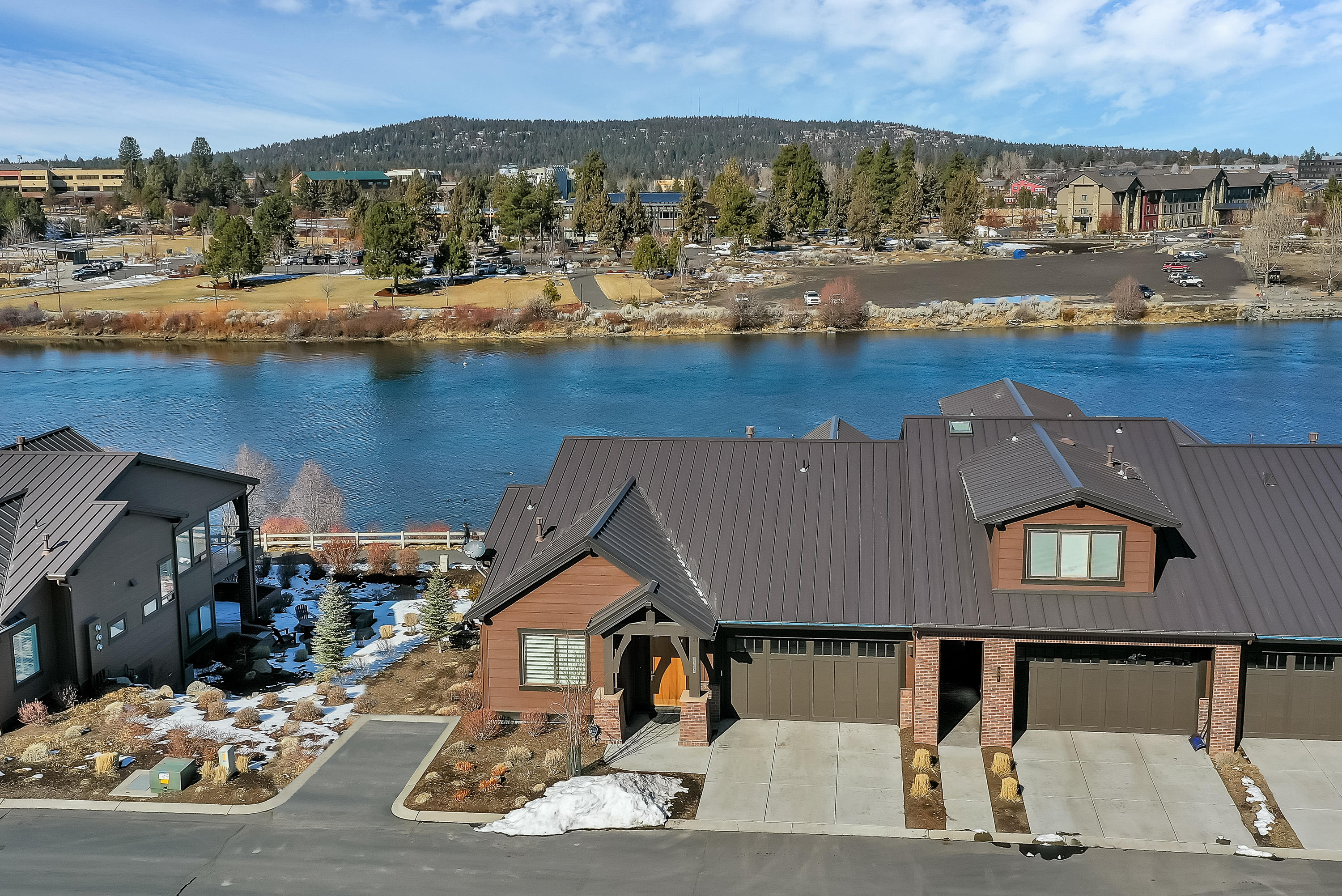 Stunning riverfront and Cascade Mountain views from this well appointed townhome on the banks of the Deschutes River just steps from The Old Mill District with a plethora of dining, shopping and entertainment at your doorstep. This is the perfect launching pad for all your Central Oregon activities.
This well considered open floor plan offers a spacious, vaulted great room with gas fireplace, chefs kitchen, main level master, luxurious master bath, powder room, dining room, and laundry. Downstairs amenities include 2 additional guest rooms, jack and jill bathroom,plus additional full bath,  media room with wet bar and beverage refrigerator, wine cellar/spacious storage closet and additional washer& dryer. Enjoy the sunsets, concerts and happy hour gatherings from any of the 3 patios and firepit area. Beautifully appointed, fully furnished. A rare offering in the heart of Bend.