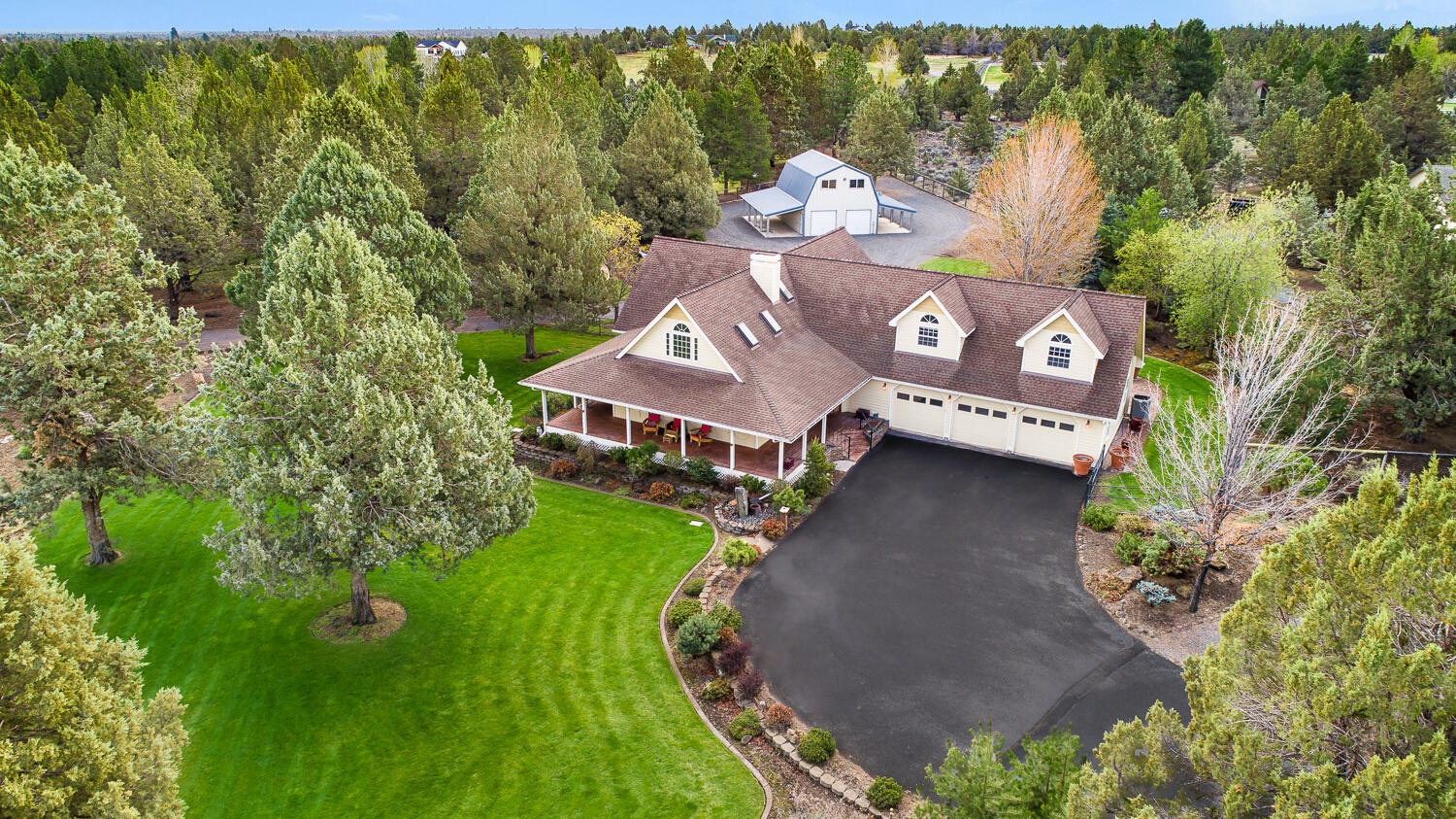 This classic farm style home sits on 2.2 acres with park like fully fenced landscaping. Enjoy the beautiful landscaping, water feature, sunsets, and wildlife from the front deck. The grand staircase is showcased by high ceilings, gorgeous wood beams, and a large rock fireplace. The main level has an office, primary bedroom suite, large living room, dining room, kitchen, and family room area. The chef's kitchen boasts stainless appliances, dual ovens and a large island. The primary bedroom sits at the end of the main level, has a large walk-in closet, dual sink vanity, tiled walk-in shower, and an exterior door leading to the jacuzzi and paver patio. The second level features two spacious bedrooms, a full bath and a large bonus room. An insulated, 1728 sq. ft. shop has an upstairs bonus room and two additional 432 sq. ft. covered storage areas on each side. Landscaping is fed by .5 of an acre of Arnold irrigation using a pond with a water fall & underground sprinklers on timers.