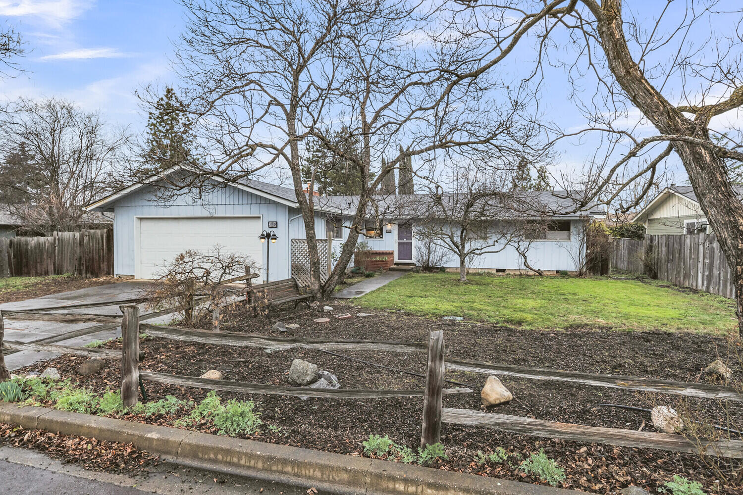 Charming 3 bedroom 2 bath single level home in desirable Quiet Village neighborhood. Located near Helman Elementary school, the dog park, and Bear Creek Greenway with easy access to the downtown area and Ashland Plaza. Lovely level .22 acre lot is a dream for gardeners and those with kids and pets who need outdoor space to run. Generously sized primary bedroom with attached 3/4 bath and large closet. Two additional bedrooms with closets and windows overlooking the large backyard. Conveniently located main bath has a shower tub combo.  Inviting living room features a wood burning fireplace and large sliding glass doors that open to the rear deck for indoor/outdoor entertaining. Dining nook off of the kitchen with large windows looks out on to the side patio area. Outdoor fireplace under the covered patio and room for a hot tub. Mature landscaping and pine and fruit trees surround the lot creating a private oasis. Home boasts a brand new roof (Jan 2024) with transferable warranty!