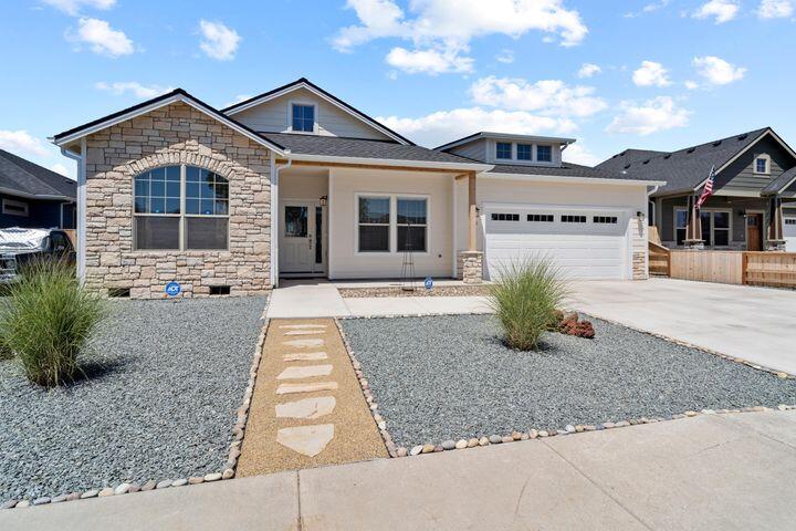 Skip the wait for new construction—this barely lived-in home is ready for you! Located in a newly rebuilt neighborhood, it's light, bright, and welcoming with vaulted ceilings and an open layout. Water-resistant laminate floors flow through the main areas, with cozy Berber carpet in the bedrooms. The kitchen shines with granite counters and stainless steel appliances, while the dining area features a built-in bar and a matching mantle over the gas fireplace. Wide hallways and minimal transitions make getting around a breeze. The guest bath has a deep tub and extra linen storage, while the primary suite boasts dual sinks, a soaking tub, and a walk-in shower. With the low-maintenance and drought-friendly yard and top-tier insulation, this home is as efficient as it is charming. Just unpack and make it yours!