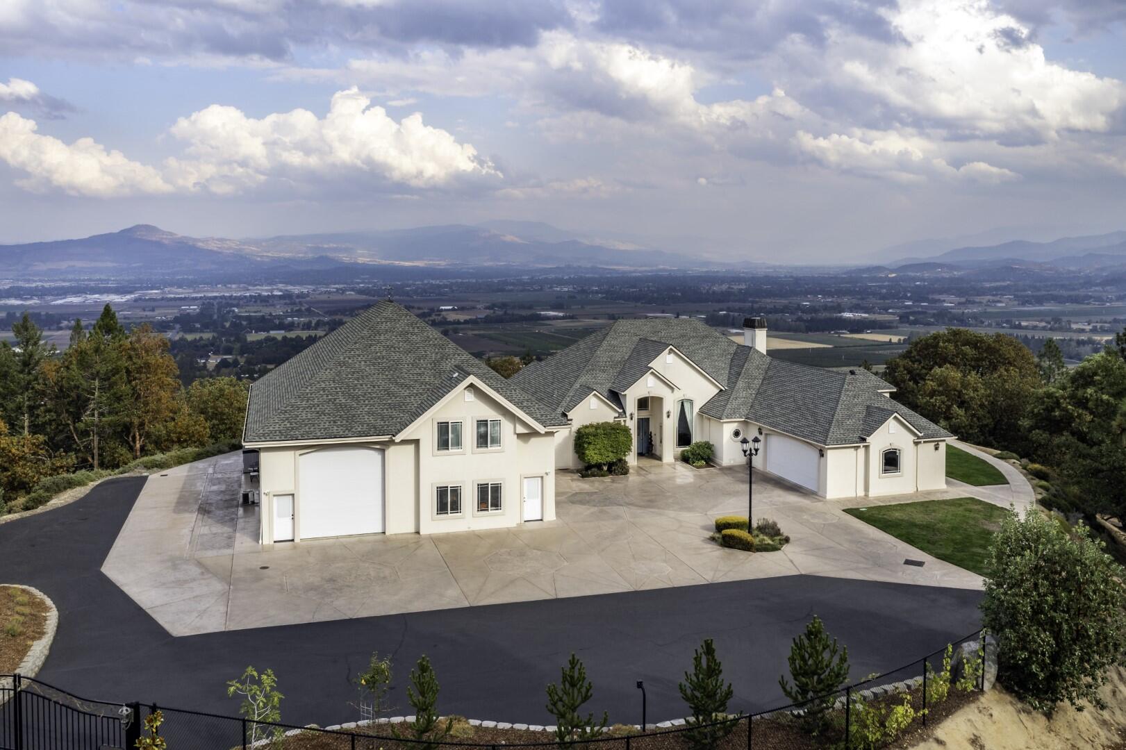 Magnificent, contemporary estate w/unsurpassed views of the valley, city lights & Mt. McLoughlin. Located w/in the exclusive Suncrest Estates community on over 20+ peaceful acres w/a private gated entry. Just minutes to Historic Jacksonville & downtown Medford, enjoy single level living in this 3 bed, 2 bath home. Soaring ceilings, hardwood floors, designer lighting, floor to ceiling windows, plus a spacious & open split bedroom floorplan, ideal for hosting & entertaining. This property lies at the top of the hill on very flat, usable grounds w/handicap access & No Stairs! Large, open chef's kitchen w/granite countertops, ss appliances, abundant prep space, & custom cabinetry. Luxurious master retreat w/a spa-like ensuite, spacious walk-in closet w/built-ins, & a sitting area w/a wall of windows to bring the outdoors IN! Fantastic 2 story, 3,000 sq ft shop w/additional finished living space, 2 car garage, & HUGE finished RV garage. Truly a spectacular home on a very special property!