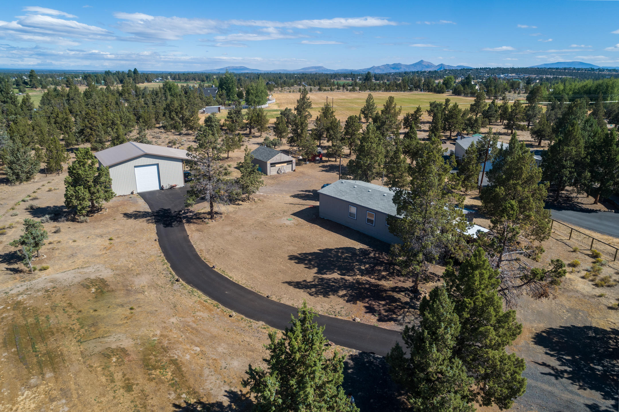 Enjoy Cascade Mtn VIEWS from the SW edge  of Redmond. Situated in an area less traveled, plenty of wildlife, elbow room, an amazing shop plus a home to call your own. Great room layout w/Master separation, open living & dining & kitchen w/SS appliances. Den or office w/built in desk & storage too. Breakfast nook off the mud room is a great spot to enjoy the view each morning. Kitchen has been updated & bedrooms are spacious w/nice closet space. Covered porch to enjoy summer thunderstorms & winter snow. Paved driveway leads back to the shop & RV storage bay. Additional double car garage/barn needs a bit of TLC - great storage! Chicken coop is ready to go & there's plenty of space for a horse or two. Lot is treed & very private. Quick access to amenities, Redmond airport, medical, Hwy's & Bend. Don't miss this one!