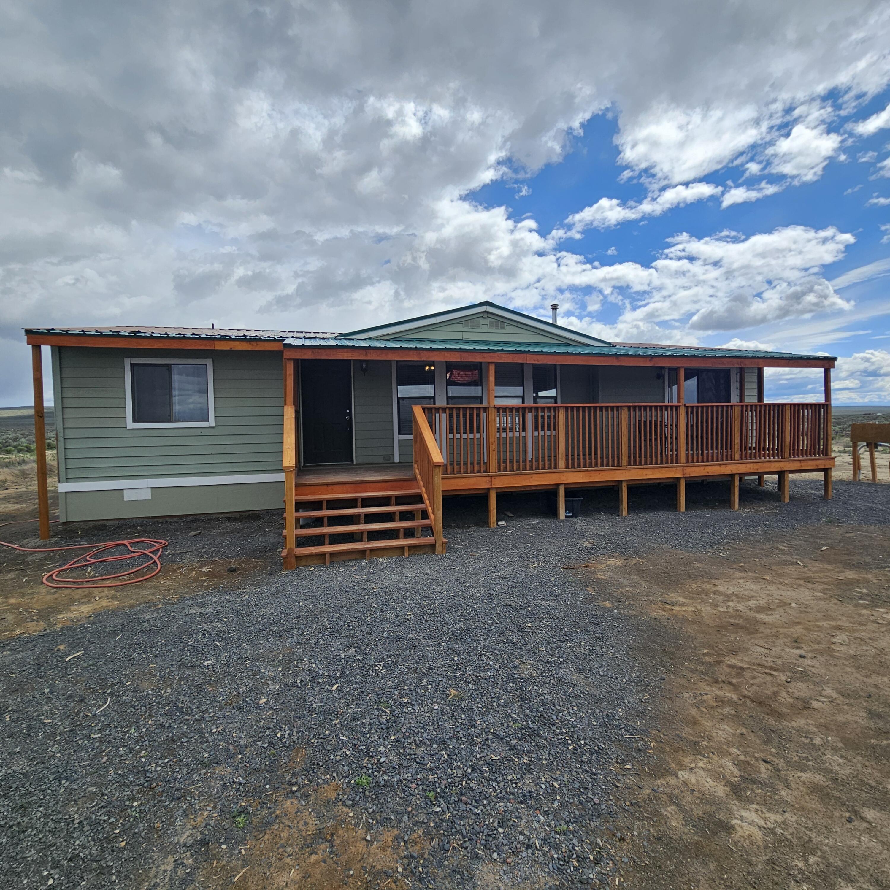 Enjoy dark sky nights and amazing sunrises east of St. Patricks Butte on this natural 20 acre parcel. The manufacture home has been moved 1x but is fully permitted and offers boundless opportunity for those seeking an open floor plan with 3 spacious bedrooms and 2 full baths. The attached green house offers 3- season growing and a good starting place protected from the elements and range life. There is plenty of room to build a shop or garage, and the storage shed/well house offers short term solution Previous tion to storing of tools.  Buyer lost their funding due to sale fail on their end. Home has been inspected and repairs of note addressed. This is one to see!