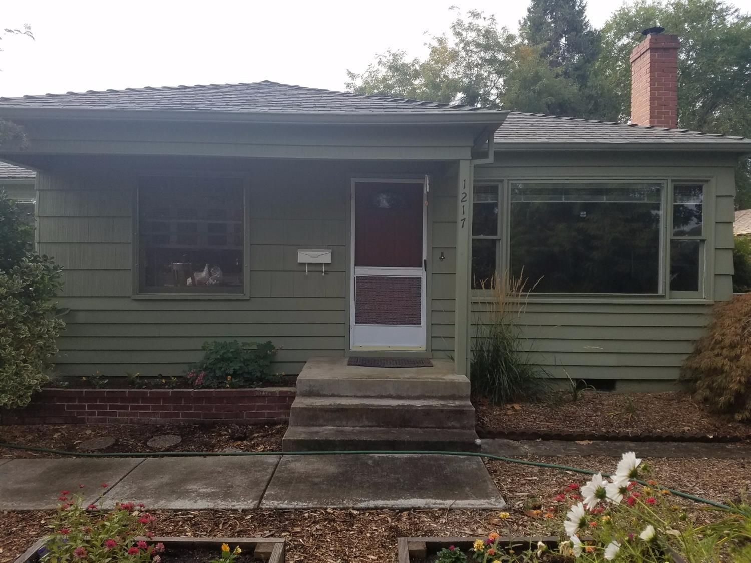 Urban Retreat! Pull into your driveway and enter into your own green space. A 50's era home on beautiful .18 acre lot with alley access. This is a solid, well maintained home with 1 car garage as well as a separate, detached carport/shed with alley access. Great property for gardeners with mature plants & flowers in front and backyard along with a large vegetable garden. Original hardwood floors throughout much of the home. Efficient wood stove for cozy winter nights and bonus room which makes a great 3rd bedroom or master.