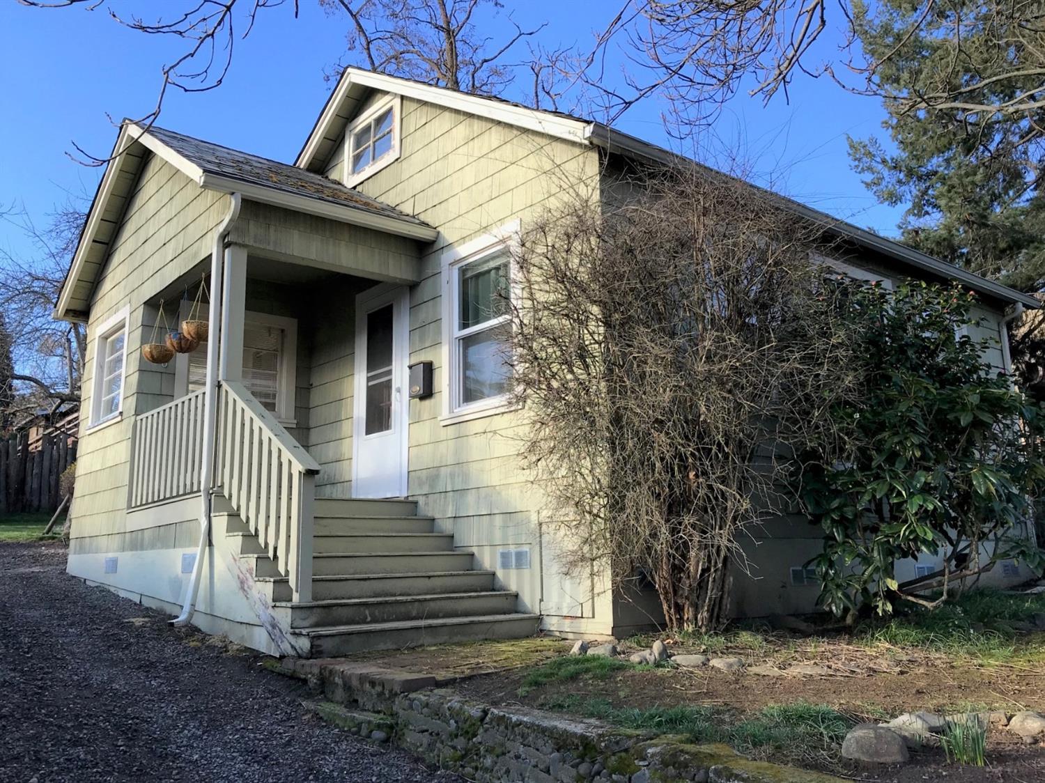 Cute little Ashland cottage in a great location close to town. Nice sized R-2 lot with the home sitting in the front of the lot, possible ADU? Needs some TLC, a bit of a gem in the rough, but a great investment at this price. Mitsubishi ductless wall units in the living room and bedroom. Finished attic with skylight was being used as a sleeping area but does not qualify as a legal bedroom. Could be craft room, artist studio or storage. Big backyard with two storage sheds.  We are in the process of having the back fence replaced and will be completed by close of escrow.