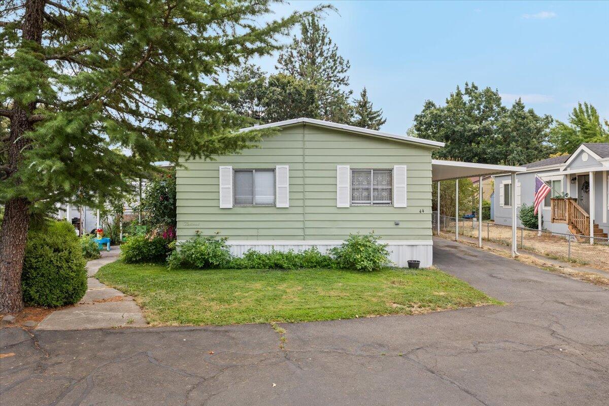 Do not miss the chance to make this beautifully kept manufactured home yours. Located in an all age park on the peaceful countryside of Central Point while still being close to town, this 3 bedroom 2 bathroom home has the perfect mix of comfort and functionality with a spacious split floor plan. The kitchen features modern cabinetry and plenty of counter space, perfect for cooking and entertaining. A wood stove adds a warm and cozy touch to the living room while large windows fill the space with natural light. Plus, the home now has a brand new mini split system to keep you comfortable year round. Step outside and enjoy the covered front porch for your morning coffee or evening sunsets. The oversized carport fits up to three vehicles, and the large storage shed gives you extra space for tools, toys, or hobbies. The yard has room to garden, play, or simply relax and enjoy the peaceful surroundings. Homes like this do not come up often in this area, so schedule your showing today!