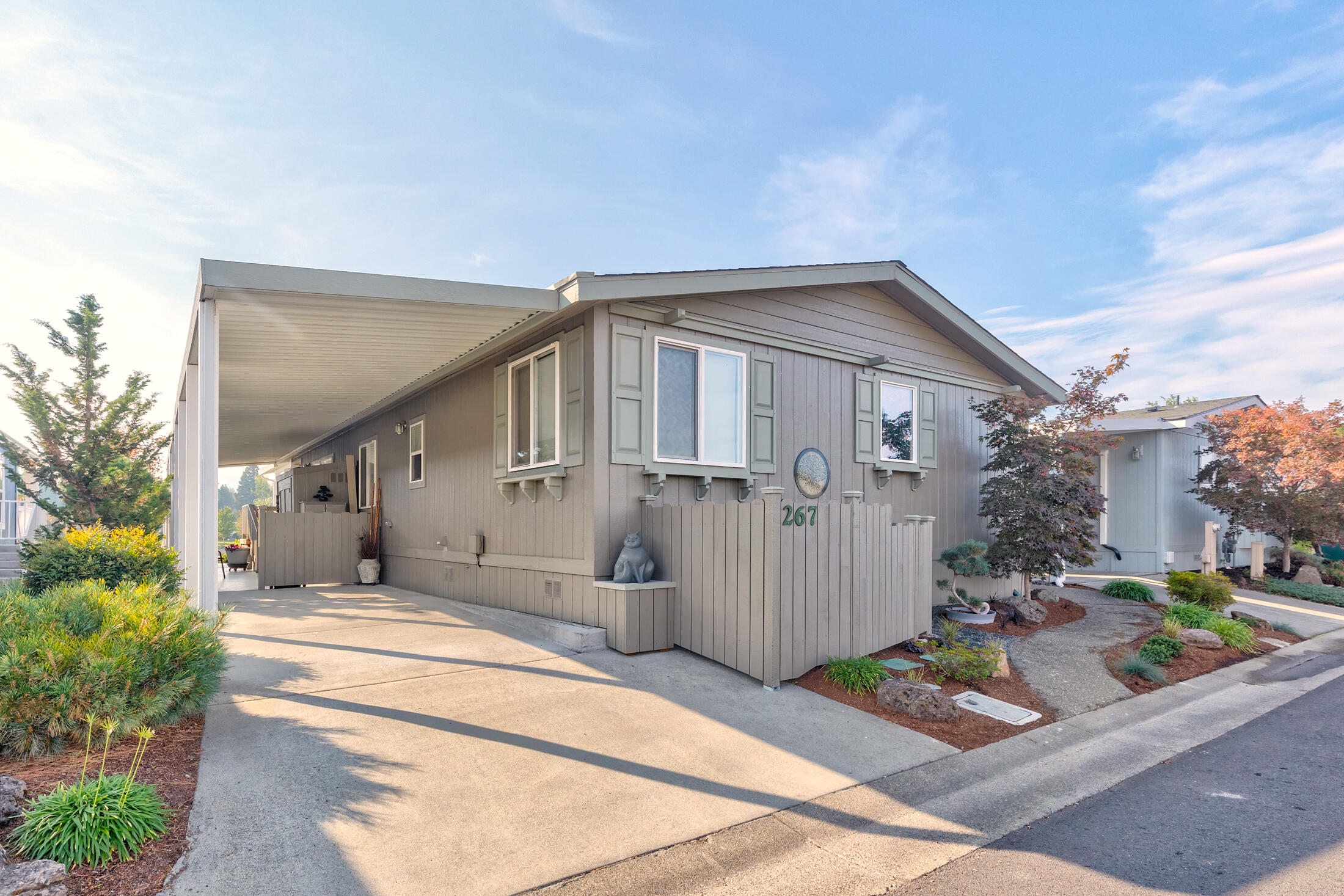 Beautiful lakefront manufactured home with spacious deck, courtyard and patio. Completely remodeled, situated in Westlake Village, the premier 55+ manufactured home park in the Grants Pass area. 1524sf, built in 1992 with 3 bedrooms including a primary bedroom with walk-in closet, 2 full baths. Comfort height American-made toilets. Grab-bars for safety & comfort.  All electric home with 3 sun tunnels, vaulted ceilings & newer energy efficient furnace & heat pump with average monthly electricity cost of $88.  Appliances included newer, better appliances include Kenmore French door refrigerator/freezer, Kenmore smooth-top range with convection oven, over the range microwave/vent hood, Amana dishwasher, garbage disposal, Speed Queen high-capacity washer & dryer.  The home has vaulted ceilings, custom (KA Designs) lacquered hardwood cabinetry throughout, with lazy-susans plus pull-out tray/drawers in pantry/kitchen, both bathrooms, utility room.  Monthly space rent will be $785.