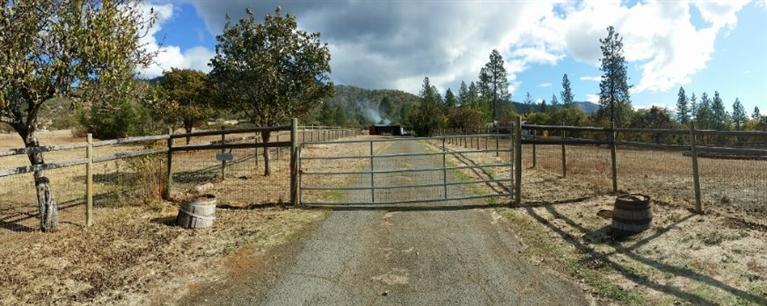As you drive through the gate, past the fenced pasture on one side and the paddock on the other, park next to one of the fruit trees and take in the peace and quiet of this valley. Before you step onto the front deck, turn and look at the mountains that frame the rugged horizon. Then enter the open plan layout, take in the solid maple floor, go past the sunken living room, into the large kitchen with stainless steel appliances, custom wood cabinets and granite countertops. Sit at the high counter, or go through the sliding glass doors to the partially covered back deck and imagine entertaining, Imagine enjoying the seasonal stream and the shade of the Madrone trees while sitting on the back deck in front of the Master bedroom with a cup of morning coffee. As you walk outside past the large garden, behind the barn, stand just beyond the pasture fence and take in a fabulous view of the valley and think about this spot for a vineyard. This is the Southern Oregon Lifestyle you wanted.