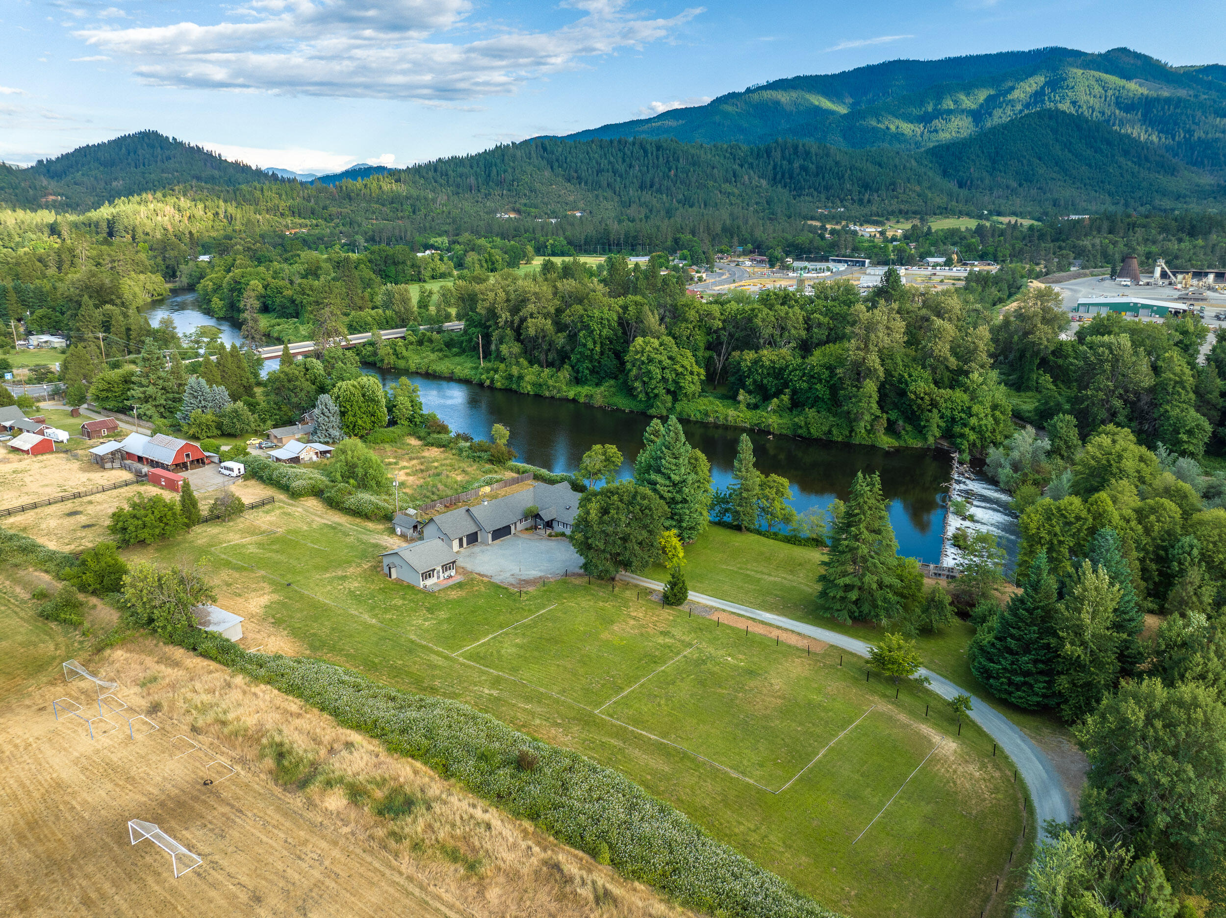 Welcome to your own Oregon Paradise! This dream property offers roughly 375ft of Applegate River frontage, a spectacular 3,227 sqft single-level home that sits right on the river, a charming guest quarters/''ag building'' AND a fully fenced, irrigated pastures w/ a full barn perfect livestock & horses.  As you enter the main home, this light filled floor-plan will take your breath away as you gaze out to the river through the large windows in the living room. The kitchen is a chef's dream w/ large island, concrete countertops, & a massive propane range w/ two ovens. This home boasts 4 bedrooms that includes 2 primary suites each with their own bath, plus 2 more guest rooms & a bathroom. Additionally, the 3-car garage provides ample storage & parking. The guest quarters comes complete w/ its own kitchenette & living area perfect for visitors or in-laws. You can have all this while being just minutes to downtown Grants Pass, the Applegate Valley Golf Club and Wineries!