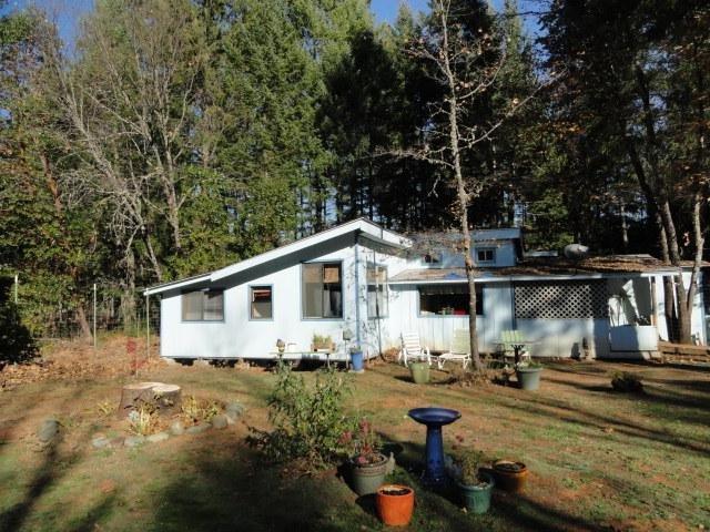 Over 10 acres of beautiful, useable level property. Plenty of room for gardening. Marketable timber. Fruit trees. Private and secluded yet just 3 miles to town. Well produces approx. 5 GPM. Legal septic system. Self sustaining and off grid, this 2 bedroom, 1 bath home is powered by a sophisticated automated system which includes 8 solar panels, 2 solar chargers, 1 2500 watt inverter, 7500 watt diesel generator, and a battery bank. Home is warm and cozy, heated by woodstove and freestanding radiant kerosene heater. stove/oven, dryer and water heater are propane. Home was built without permits & being sold in as is condition. Handicap accessible. Private and Peaceful.Cash Only. Will not finance