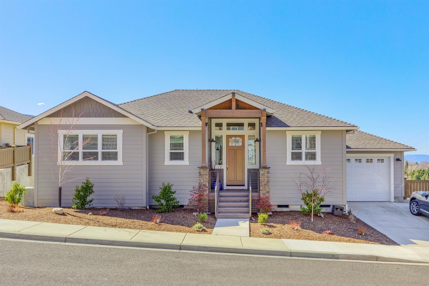 Stunning newer home with every attention to detail throughout. There are 180 degree breathtaking views from Mt. Ashland north from the entire main level. Choice corner lot overlooking Kestrel & Bear Creek Greenway. Open floorplan, expansive living area with wood grain laminate flooring. Spacious kitchen has quartz countertops, glass tile backsplash, stainless appliances & walnut cabinets. Main level master boasts a walk-in closet, vaulted ceilings, & stunning bathroom w/ travertine shower. Upper balcony provides a great spot for taking in the surrounding views. There is an additional bedroom on the main floor and an oversized laundry room. With a second living area, good-sized third bedroom and additional full bath, downstairs is perfect for overflow guests. Plenty of storage space throughout including over 200 square feet of bonus storage in addition to the attached garage. The landscape is low maintenance, with a fully fenced backyard & hot tub!