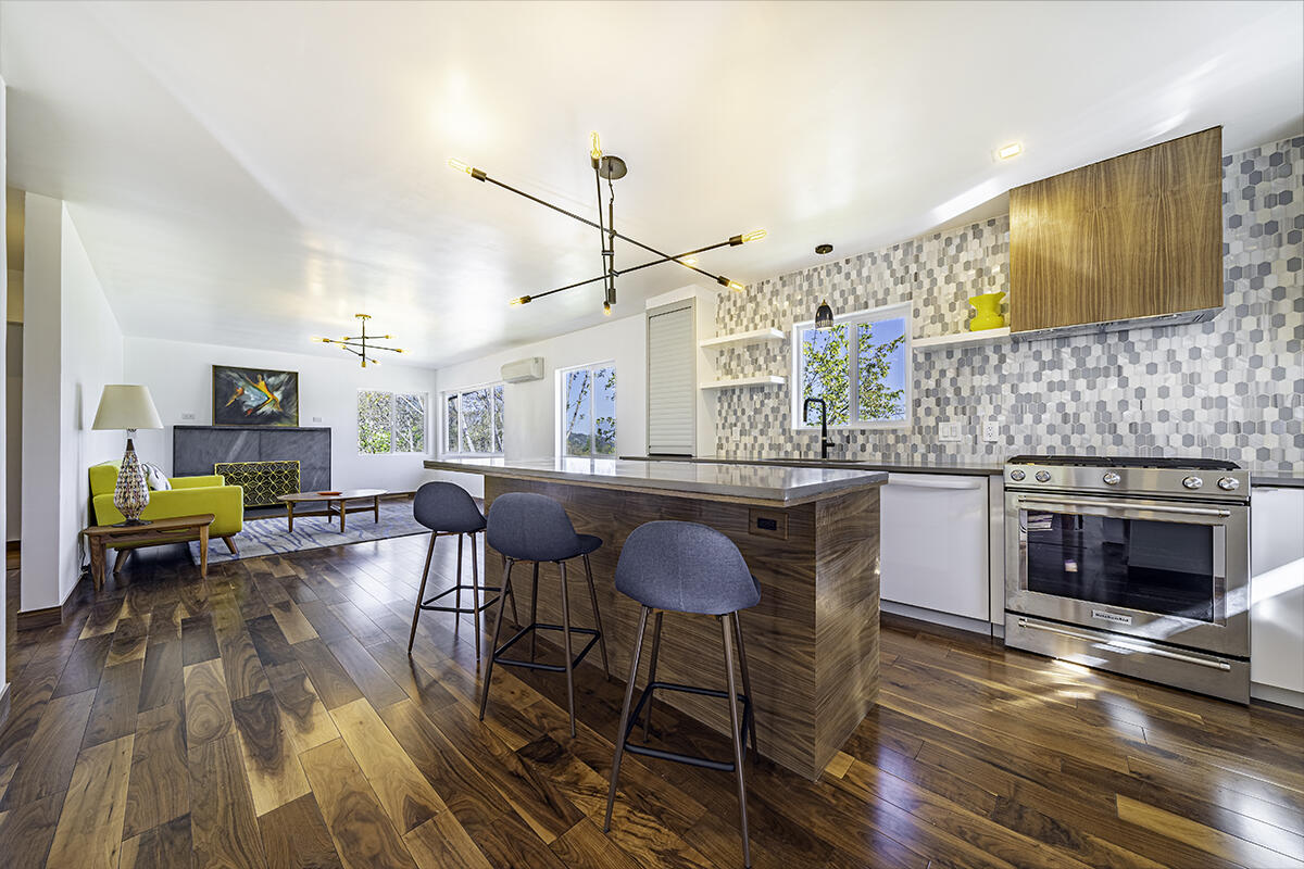 You will love this sleek Euro-Modern design with wonderful finishes! View property above the college with open contemporary floor plan. The rich walnut flooring combined with quartz counters, designer tile and white cabinets creates a crisp and artistic interior. Fabulous kitchen with large quartz island and dining bar, stainless gas range and textured tiled backsplash is open to the living and dining rooms. The living room has a stone-faced fireplace and large view windows. This is comfortable and stylish living. Main level bedroom and bathroom with soft-close barn doors, geometrical 3D tile & leather cabinets. Roomy lower-level features 3 additional bedrooms, full bath with barn door & dual sinks, 3D tiled half wall & shower & laundry. Efficient mini split heating & AC system. 4'' foam in walls, lower level has no AC, not needed. All new windows, paint, pipes, 75% new electrical. Huge carport with easy conversion to garage. Views and private feeling natural outdoor spaces.