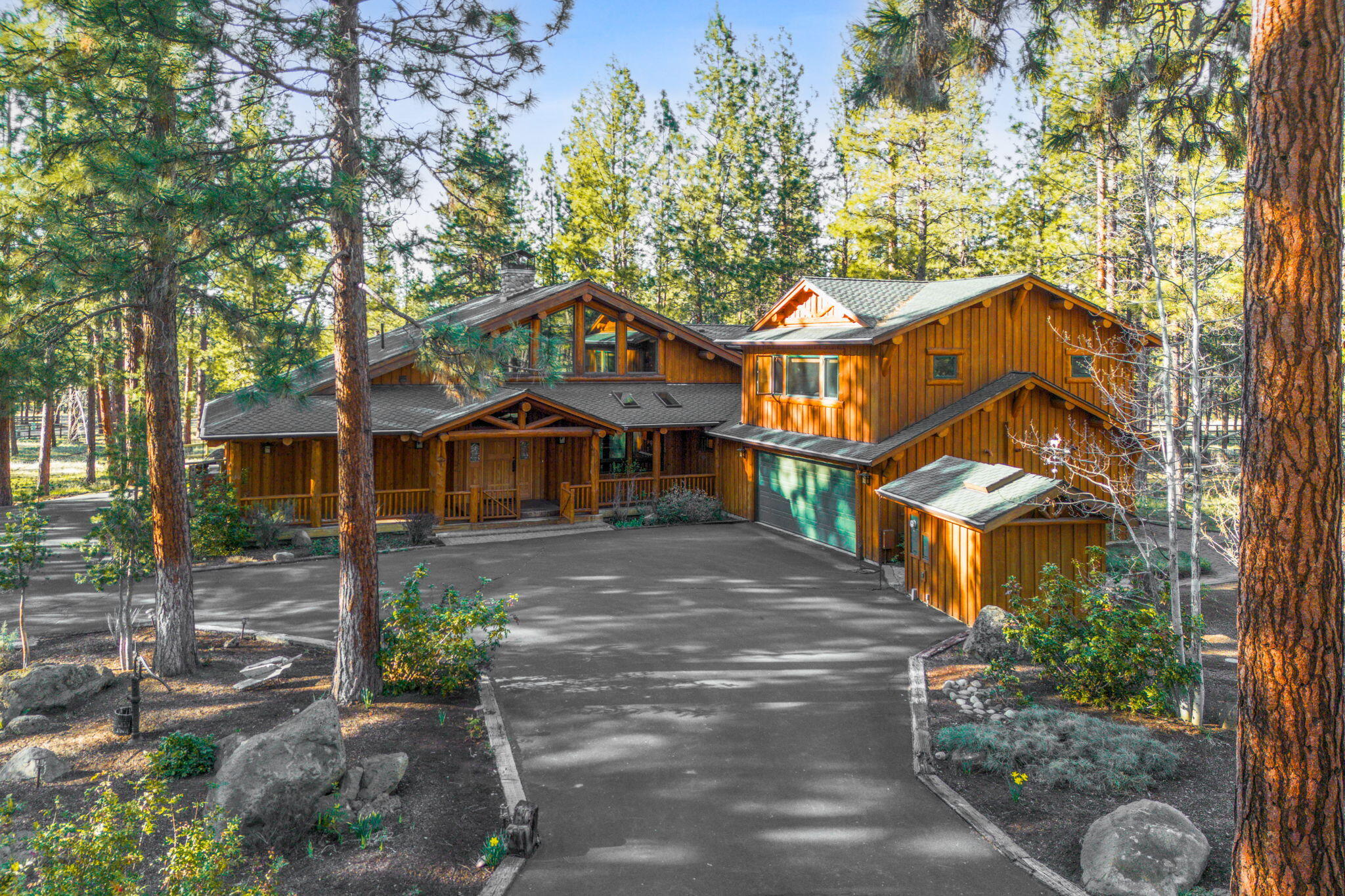 This grand log-framed estate on 4.26 acres is just minutes from downtown Sisters and is considered the premier lot in the subdivision. Surrounded by Ponderosa pines for exceptional privacy, the home showcases lodge-style craftsmanship throughout. Features include a chef's kitchen, two-story great room with river rock fireplace, and main-level primary suite. A spacious finished bonus room with full bath sits above the garage. Two guest bedrooms downstairs share a Jack & Jill bath. Enjoy zoned radiant floor heating and A/C for year-round comfort. A gated driveway leads to a 3,000± sq. ft. outbuilding with two large storage bays, a heated indoor pool, oversized hot tub (both with retractable covers), and a large craft room. The fully fenced property offers equestrian potential, a pond with dock, gazebo, in-ground propane tank, irrigation rights, and forest tax deferral. A truly rare find combining privacy, luxury, and Central Oregon charm.