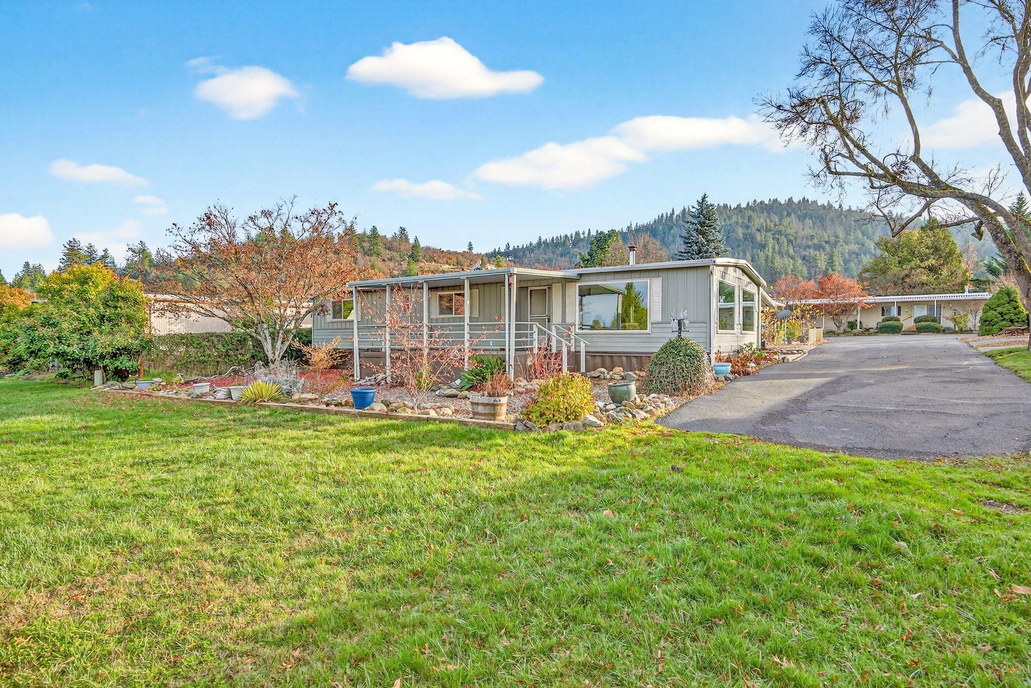 Located in a desirable park, this beautiful home blends warmth and style. Enjoy the cozy efficiency of a woodburning stove and kitchen featuring StainlessSteel appliances, tile countertops/backsplash, and buffet-style cabinetry ideal for hosting.

Situated at the end of the road, the home offers privacy, minimal traffic, and a spacious open area in front plus a large covered porch. Nestled in the foothills of the Siskiyou Mountains, this quiet park provides a peaceful Southern Oregon setting while keeping you close to the amenities of Medford and Jacksonville.