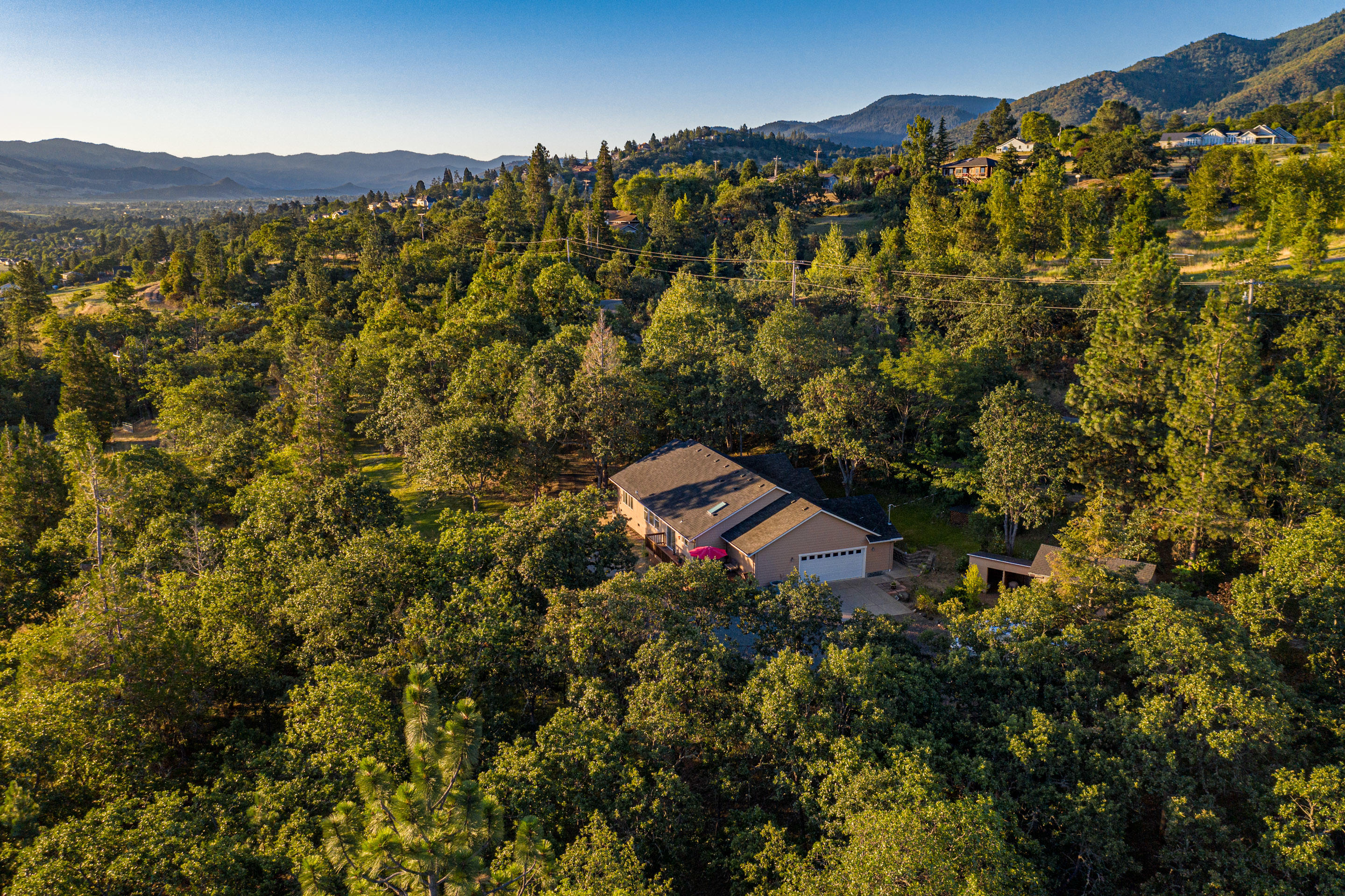 Welcome to 1182 Frank Hill Rd, a peaceful and private 3.32 acre country setting, minutes from downtown Ashland. The 3 bed, 2 full bath home, built in 2012, features spacious vaulted ceilings and great views. The open plan living space leads to the island kitchen, with granite countertops, stainless appliances, and pantry. At the opposite end of the home, the master suite features a bathroom and walk-in closet. The two guest bedrooms are next to the office, which could be 4th bdrm. The two car garage includes an attached workshop and storage space. Outbuildings include a barn, modest shop, and garden shed. Includes dedicated RV parking space. Fully irrigated (district water) and 60 GPM domestic-use well, as well as partial fence, making this property ideal for animals or gardens. This property offers the discerning buyer a great turn-key home and property that is both usable and private, all while being just minutes from sublime culture and recreational opportunities.