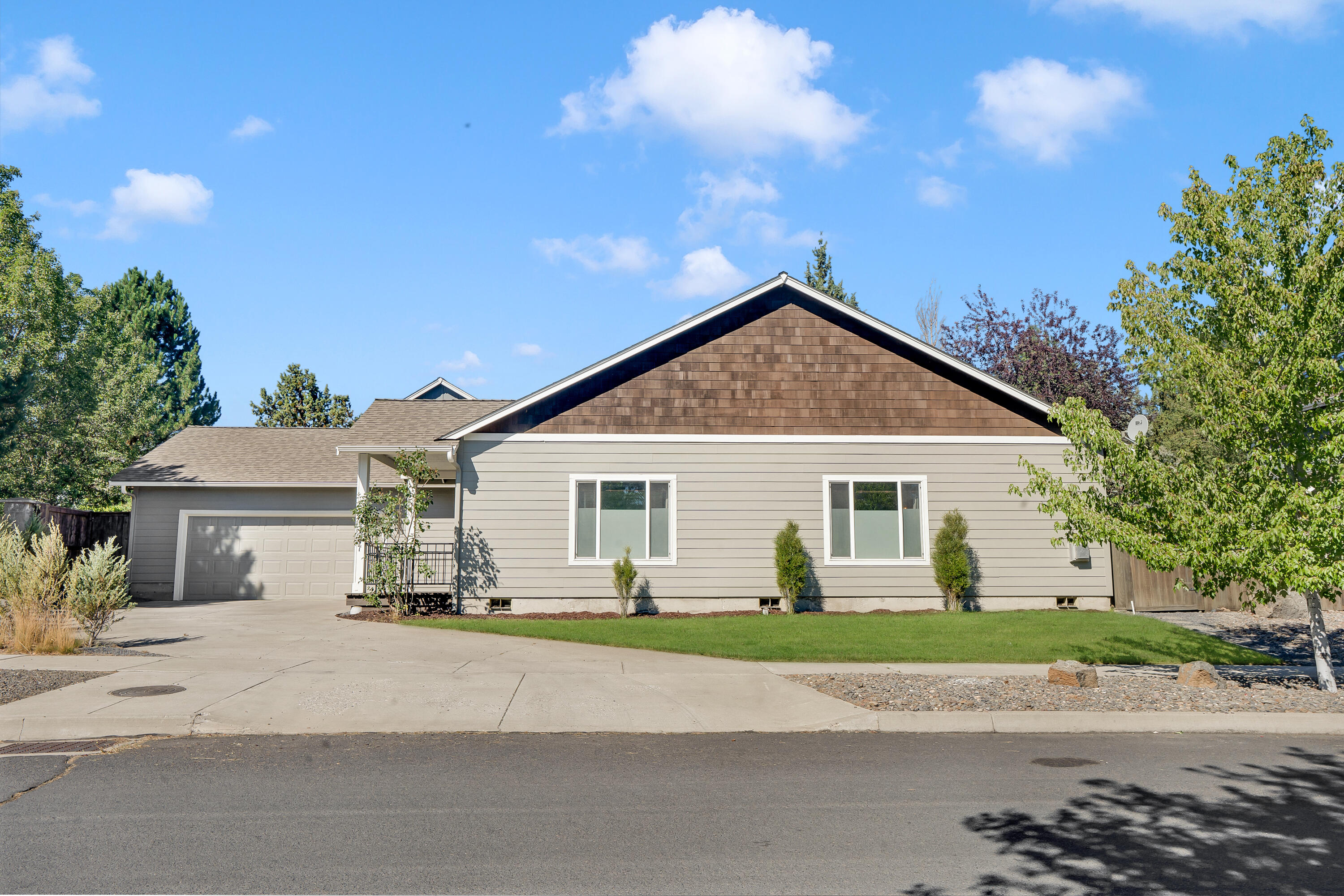 Tucked in one of NE Bend's most desirable neighborhoods, this charming single-level home offers 3 bedrooms, 2 bathrooms, and an open, airy layout filled with natural light. Vaulted ceilings and updated laminate flooring create a warm and spacious feel throughout. The kitchen shines with new stainless steel appliances, generous counter space, and a convenient eating bar. A cozy gas fireplace anchors the living area, perfect for relaxing or entertaining. Step outside to a fully fenced, low-maintenance backyard featuring artificial turf, room for a garden, and space for all your Central Oregon gear. The oversized garage adds even more flexibility. Recent updates include stylish bathroom tile and modern fixtures. Just around the corner from Rock Ridge Park - home to trails, a playground, and a picnic area - and only minutes from the new Costco, schools, and shopping. This home is move-in ready and full of comfort, charm, and convenience