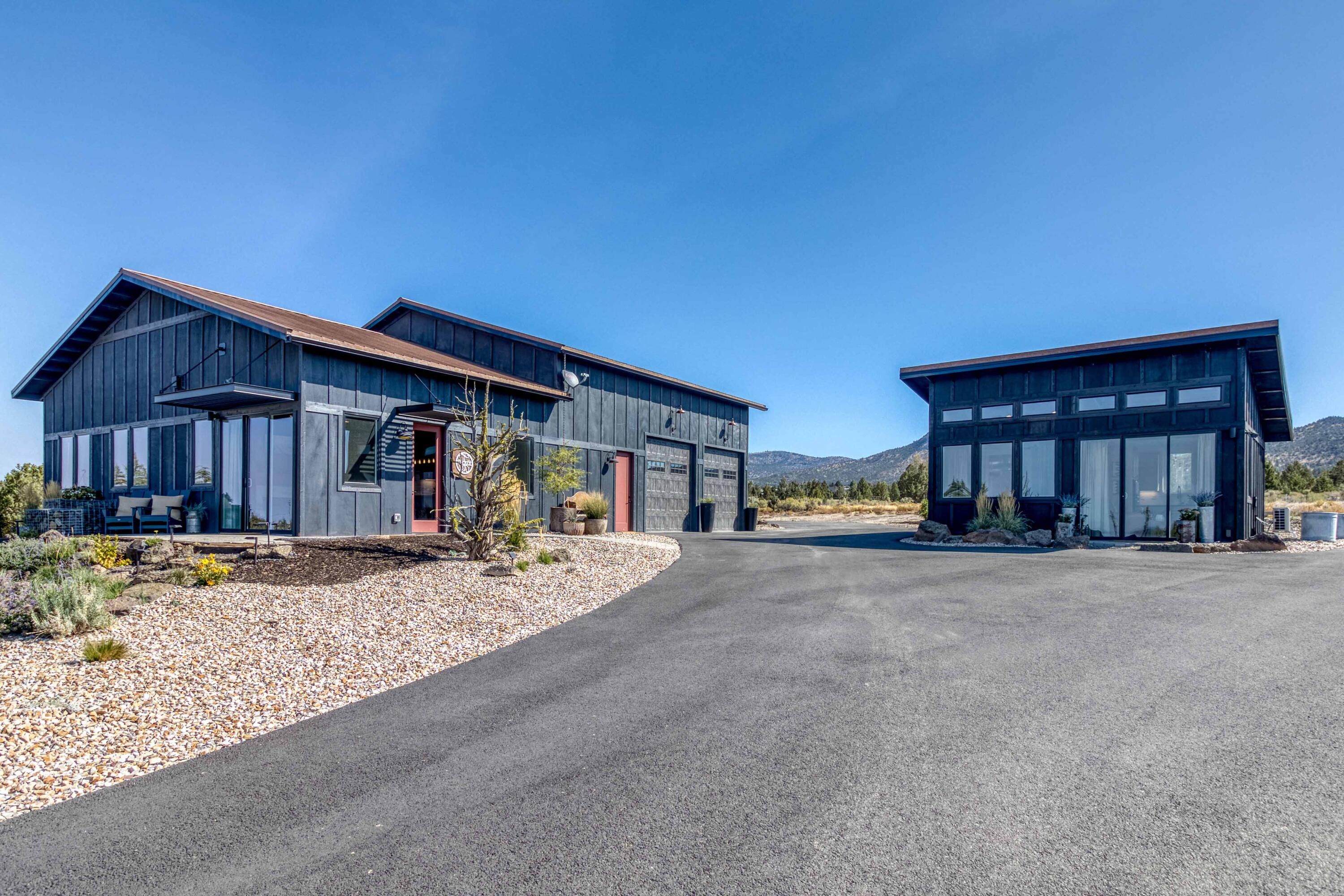 BIG mountain views on this 4.85-acre property bordering Brasada Ranch in Powell Butte!  40ft x 60ft shop contains: 14 ft RV door for your RV or boat, two 10-foot garage doors & a 960 sq. ft luxury ''barndominium'' (2 bed/2 bath)!  Home has concrete floors, tongue & groove ceilings, board & bat interior walls, 8 ft doors & an abundance of natural light. Home has all the luxury amenities: 36'' gas range, gas fireplace, walk in showers, tankless hot water heater & a swoon worthy laundry room.  In addition, enjoy a 396 sq. ft detached accessory structure/flex space complete w/a full bathroom & kitchenette. Property is gated & has preliminary work done for a large riding arena. Circular driveway is completely paved & Cascade Natural gas was brought to the property! 2000-gal. septic tank & ATT system is adequately sized for a future home.
Garage space is heated w/lots of storage capabilities.  Beautiful low maintenance landscape & artificial turf set the scene for the most amazing sunset