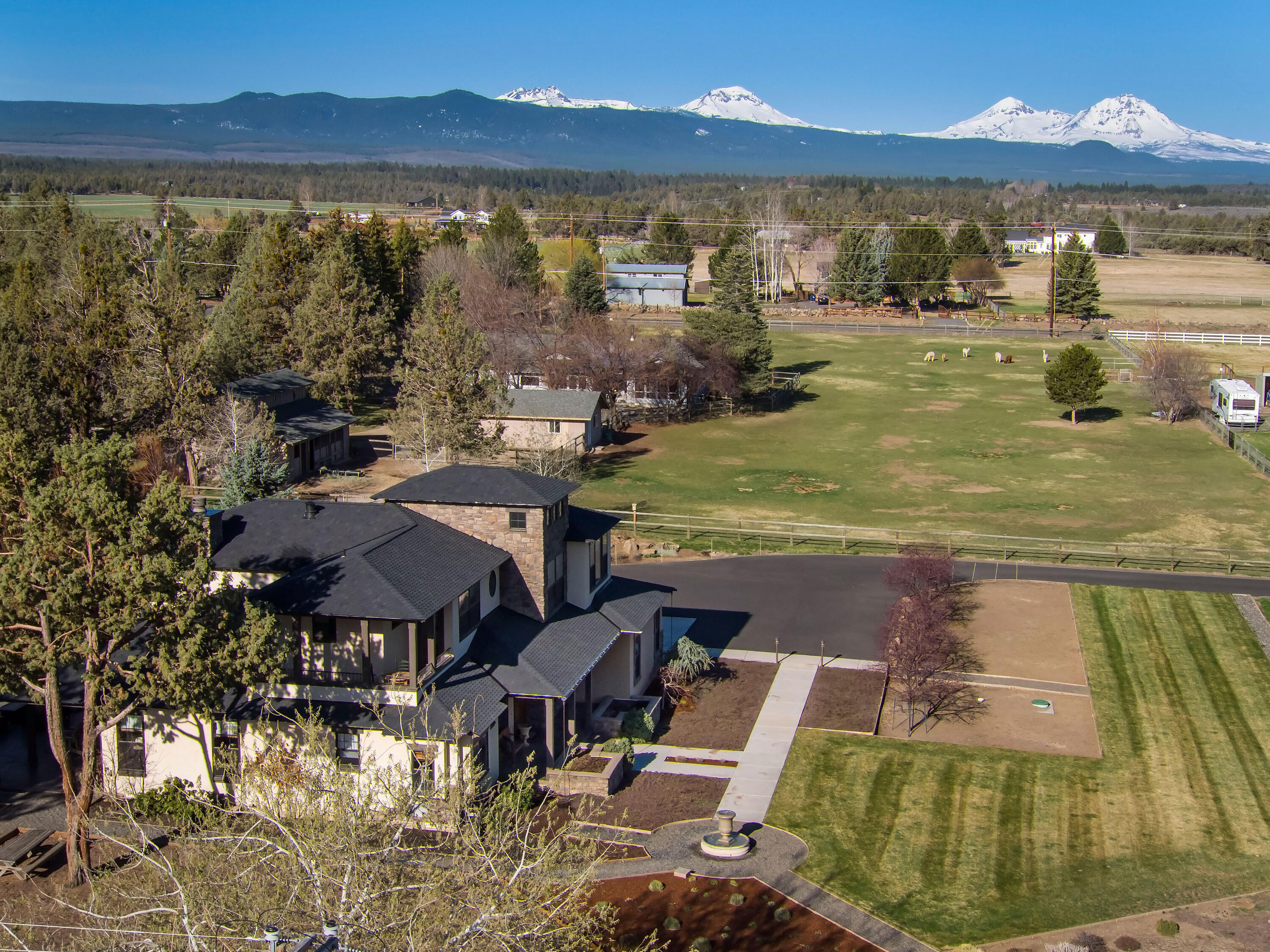 Tuscany in Tumalo! This exquisitely designed home sits on 3.21 acres with Cascade Mountain Views.  The awe-inspiring front entrance with meticulous landscaping and a bubbling fountain. Main floor features a Library, Formal dining room, Family room, Kitchen, and Laundry Room. Large windows and vaulted ceilings offer abundant natural light throughout the home. Spacious chef's kitchen w/no detail overlooked! Features include: Granite countertops, 6 Burner Gas Cooktop, Dual ovens, warming drawer, island, pantry, built-ins and organization galore. Expansive main floor primary suite w/ Double closets, Double sinks, Full tile shower w/3 Shower heads and Champagne bubble jetted tub. The second story features 2 bedrooms, Full bath and an additional Ensuite bedroom w/deck. The rear paver courtyard/patio is ideal for entertaining, including a built-in BBQ.  Attached 2 Car Garage. Detached fully insulated & heated shop w/upstairs storage/bonus space. Quiet and private setting just minutes to Bend!