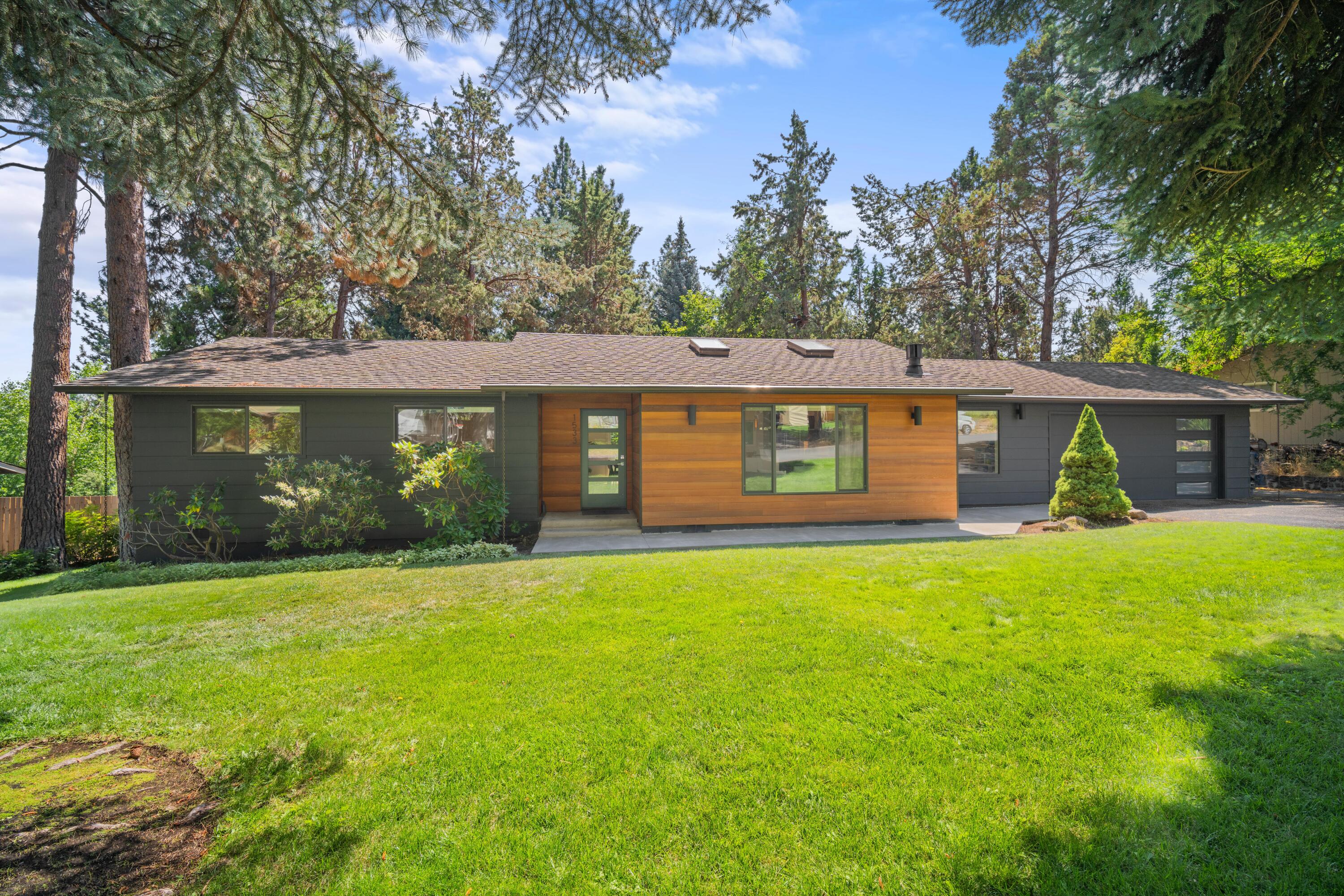 Beautifully remodeled single level ranch style home in NW Bend. It's not everyday you will find a home like this hit the market. Fantastic location, large fenced back yard w/ spacious deck, private setting w/ mature trees, single level, attached 2 car garage, and completely remodeled. This 1845 sf home sits on a private .31 acre lot w/ 3 bedrooms, 2.5 bathrooms, and an extra bonus space off the vaulted living room. Gorgeous designer finishes throughout  w/ mid-century vibes including slab quartz counters, custom cabinetry w/ several built-ins, wide plank hardwoods, and more. Spacious primary suite includes walk-in closet, soaking tub, dual vanities, modern floating cabinetry, and large walk-in tile shower. Enough said, this home speaks for itself. Don't miss your chance at owning this truly one-of-a-kind home!