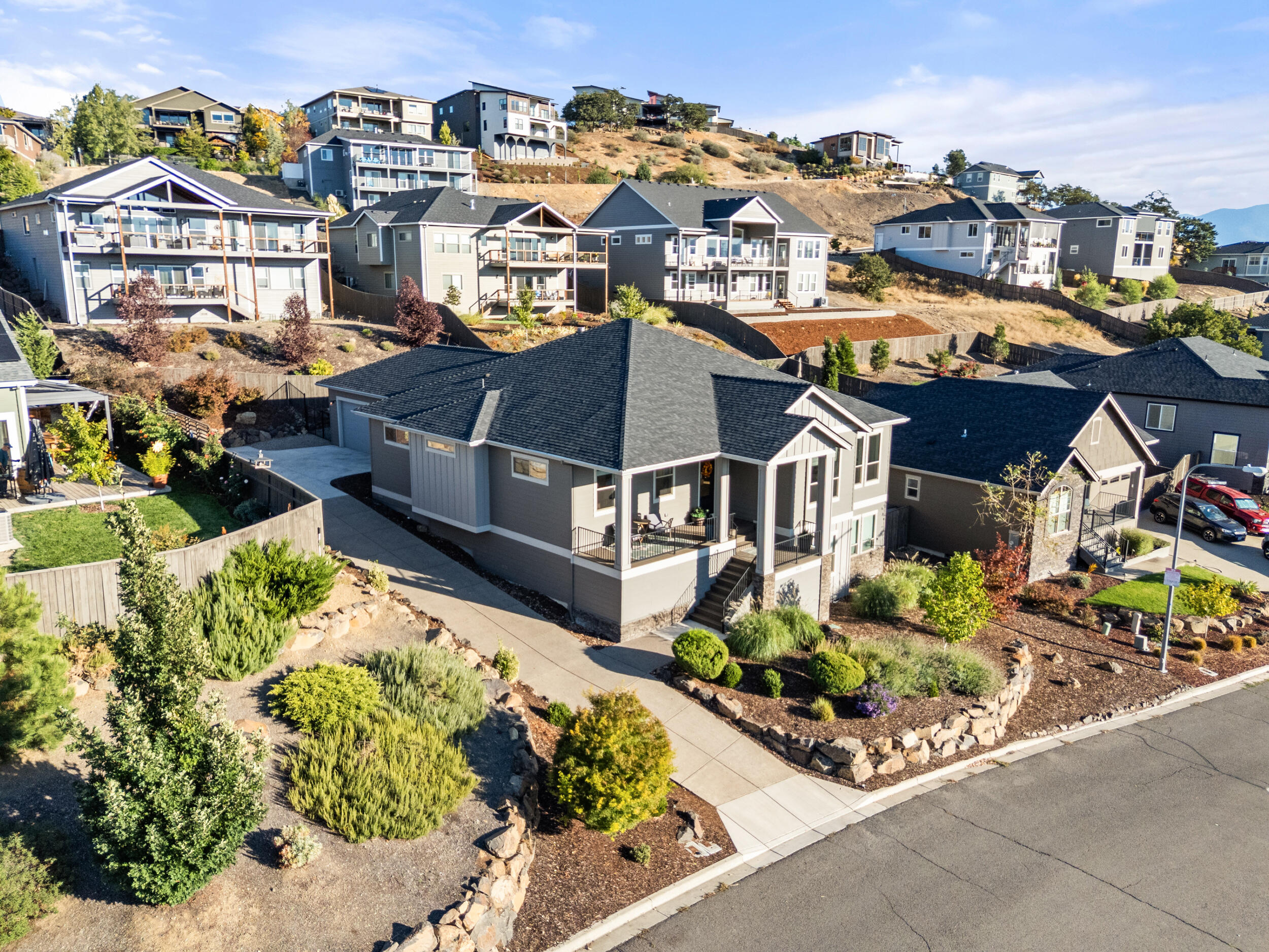 Exquisite 2,500+ sq. ft. custom home on a .23-acre landscaped lot offering refined design, modern comfort, and breathtaking Southern Oregon sunsets. With 3 bedrooms, 2.5 baths, an office, and a sun-filled bonus room that opens to private Trex decks, this residence is built for relaxation and entertaining. Inside, 10' ceilings and dramatic 13' vaults enhance the open layout, complemented by European French oak hardwood floors, 8' doors, designer lighting, and a gas fireplace with custom mantle and built-ins. The gourmet kitchen showcases granite counters, a walk-in pantry, dry bar, stainless appliances, and abundant custom cabinetry. Retreat to the luxurious primary suite featuring dual vanities, walk-in closet, and spa-like tiled shower. An oversized laundry/mudroom with built-ins adds convenience. Complete with a finished two-car garage, fenced yard, lush landscaping, and seamless indoor-outdoor living, this home blends timeless elegance with everyday functionality.